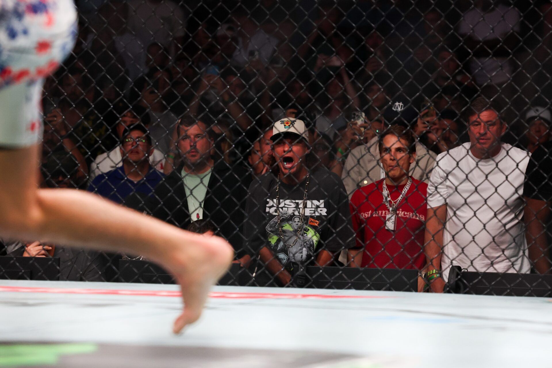 Theo Von cheers as Max Holloway (red gloves) fights against Dustin Poirier (blue gloves) during UFC 318 at Smoothie King Center.