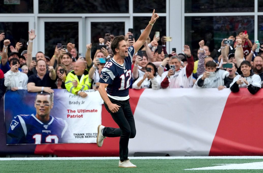 Sept 10, 2023 - Former New England Patriots quarterback, Tom Brady, runs on to the field at Gillette Stadium on Sunday evening to welcome fans as the Patriots announce they will induct him into the Patriots Hall of Fame in June. The New England Patriots host the Philadelphia Eagles in their home opener at Gillette Stadium on Sept 10, 2023. [The Providence Journal / Kris Craig]  POY23KC