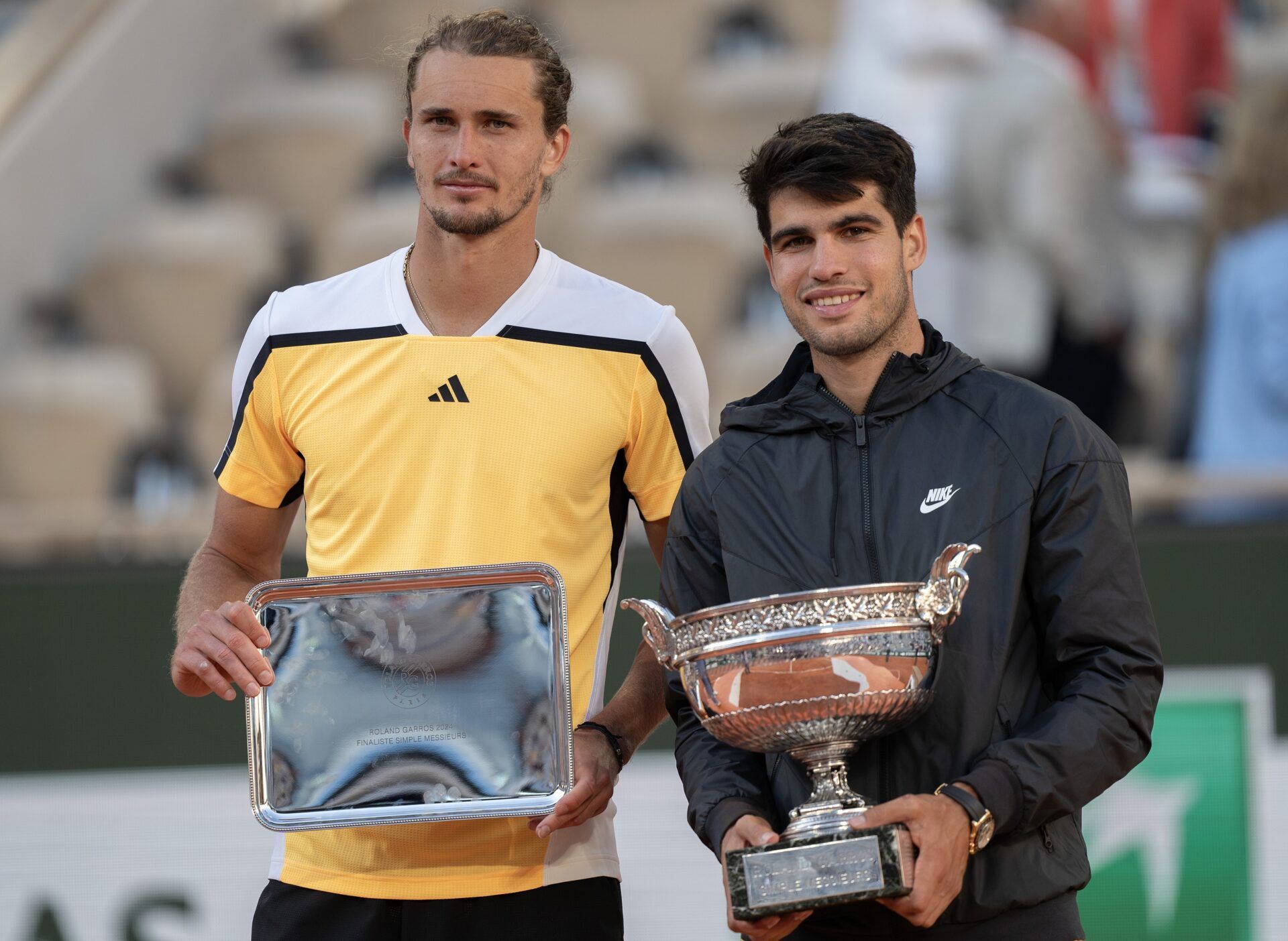 Carlos Alcaraz of Spain and Alexander Zverev of Germany pose with their trophies at the trophy presentation on day 15 of Roland Garros at Stade Roland Garros.