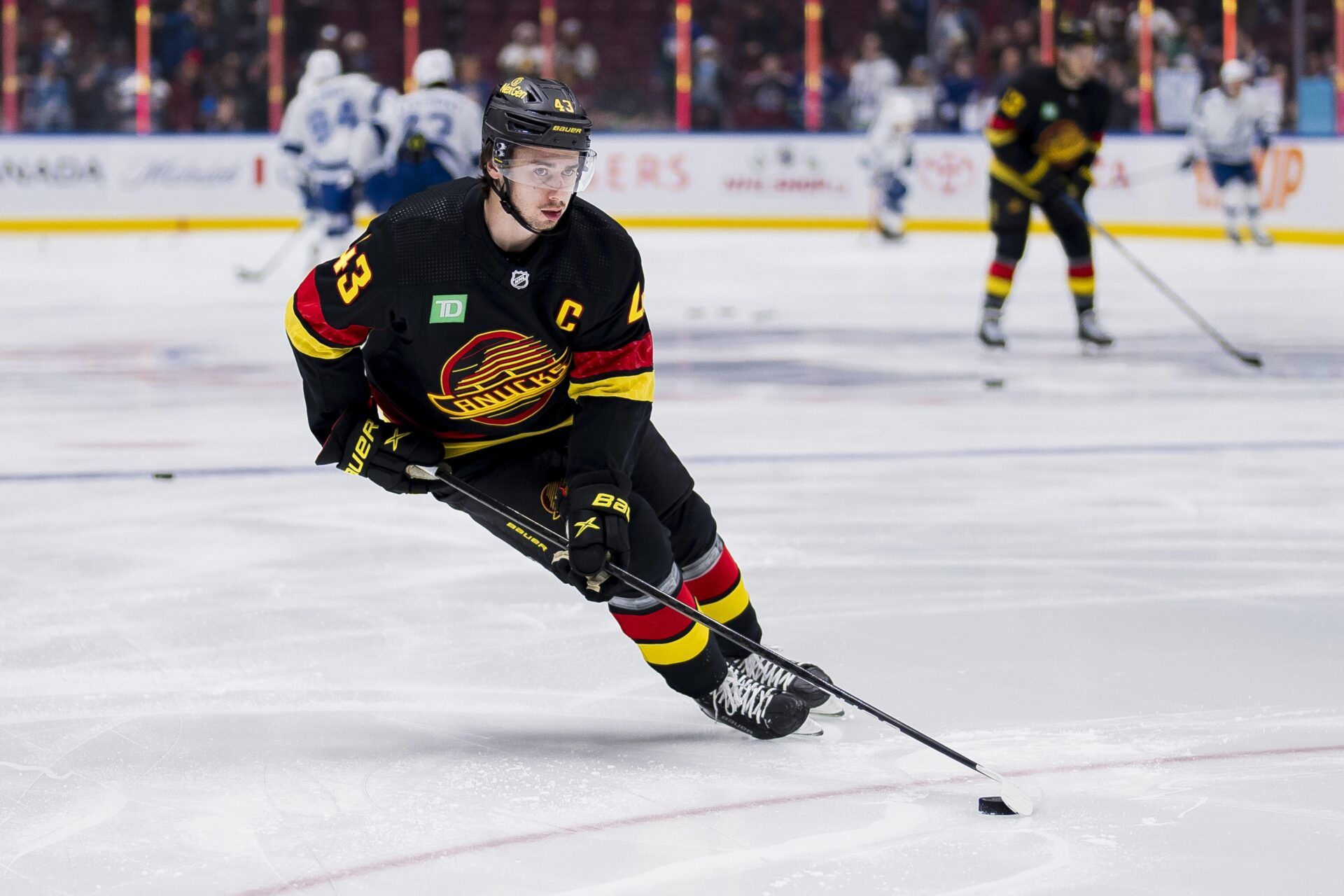 Vancouver Canucks defenseman Quinn Hughes (43) handles the puck during warm up prior to a game against the Tampa Bay Lightning at Rogers Arena.