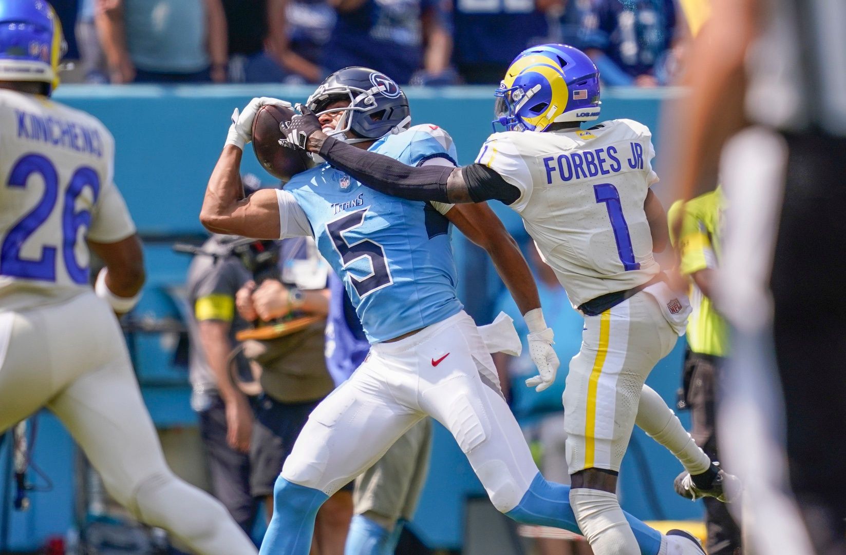 Tennessee Titans wide receiver Elic Ayomanor (5) pulls the ball down ahead of Los Angeles Rams cornerback Emmanuel Forbes Jr. (1) during the second quarter at Nissan Stadium in Nashville, Tenn., Sunday, Sept. 14, 2025.