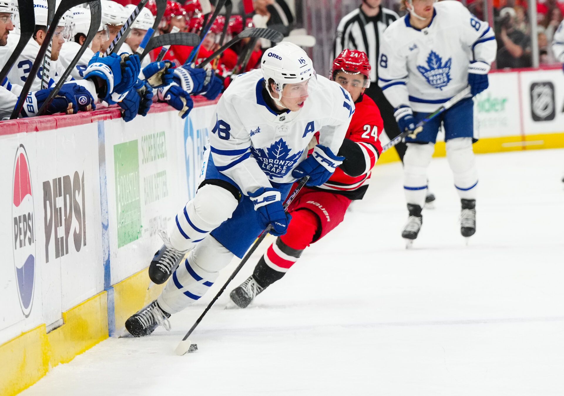 Toronto Maple Leafs right wing Mitch Marner (16) skates with the puck against Carolina Hurricanes center Seth Jarvis (24) during the first period at Lenovo Center.