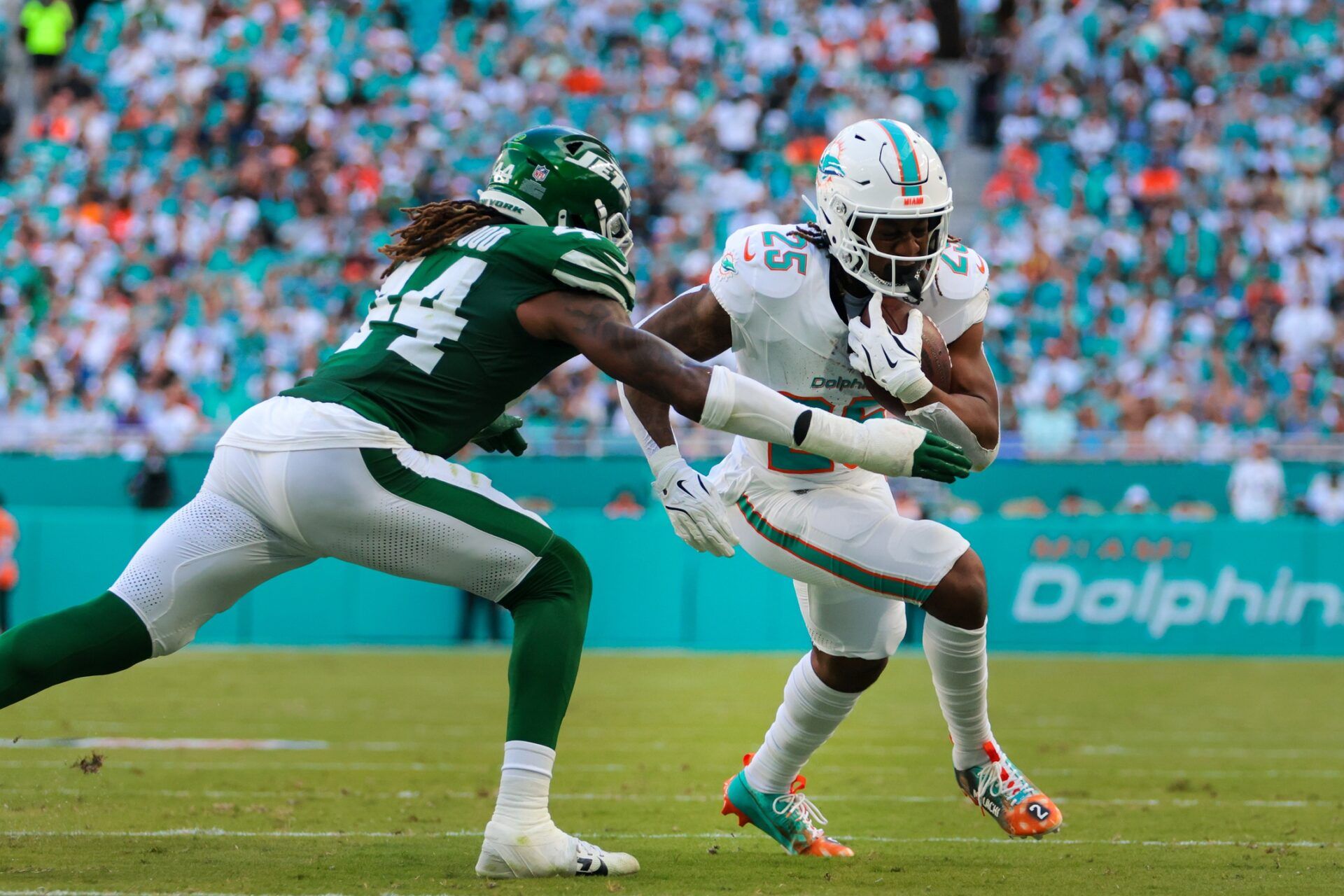 Miami Dolphins running back Jaylen Wright (25) runs with the football against New York Jets linebacker Jamien Sherwood (44) during the second quarter at Hard Rock Stadium.