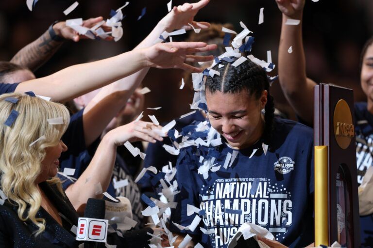 Connecticut Huskies guard Azzi Fudd (35) gets confettied by her teammates while interviewed by ESPN reporter Holly Rowe after the national championship of the women's 2025 NCAA tournament against the South Carolina Gamecocks at Amalie Arena.