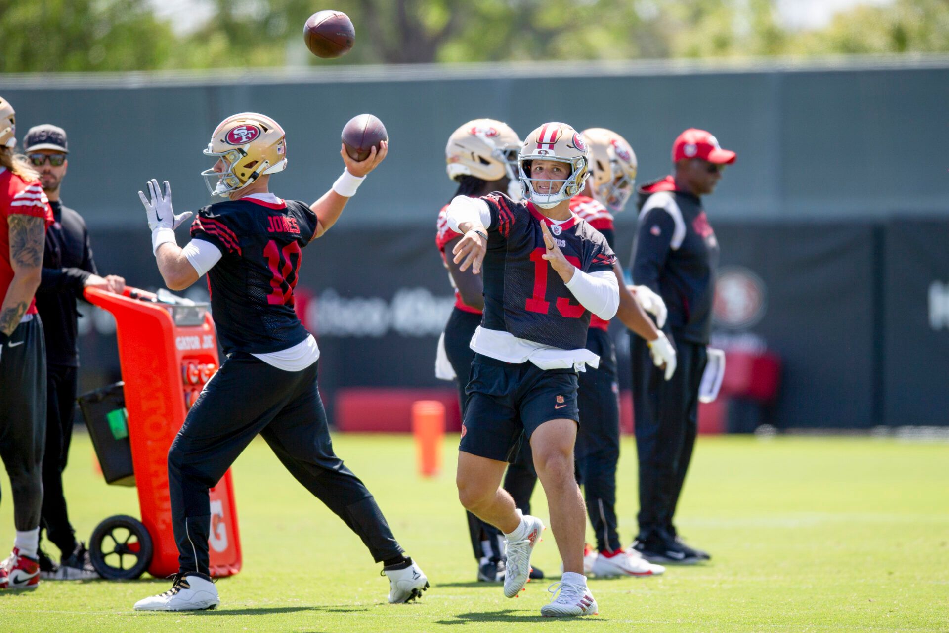 San Francisco 49ers quarterbacks Mac Jones (10) and Brock Purdy (13) work on passing drills during a team OTA at Levi's Stadium.