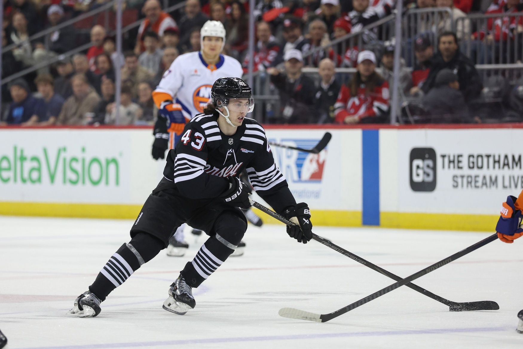 New Jersey Devils defenseman Luke Hughes (43) skates with the puck against the New York Islanders during the second period at Prudential Center.