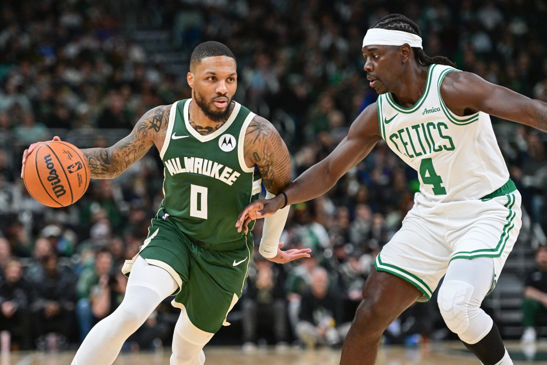 Milwaukee Bucks guard Damian Lillard (0) drives for the basket against Boston Celtics guard Jrue Holiday (4) in the first quarter at Fiserv Forum.