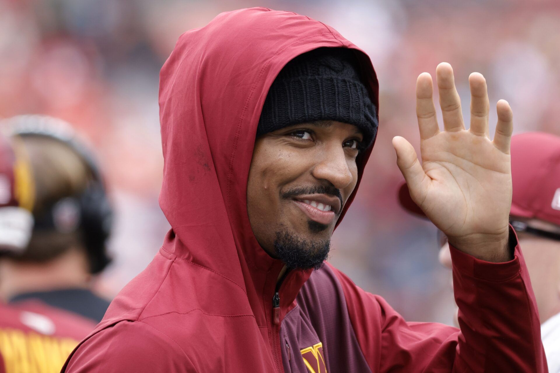 Injured Washington Commanders quarterback Jayden Daniels  waves to fans while walking off the field after the Commanders' game against the Las Vegas Raiders at Northwest Stadium.