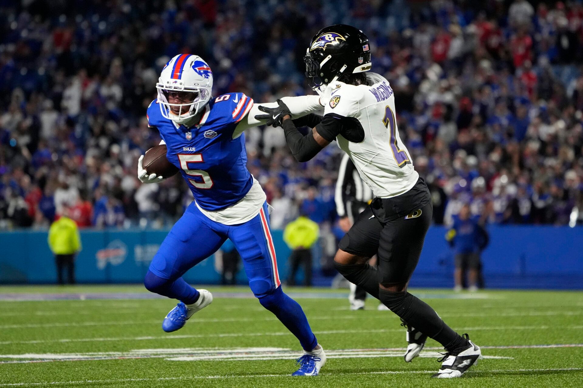 Buffalo Bills wide receiver Joshua Palmer (5) runs the ball against Baltimore Ravens cornerback Nate Wiggins (2) during the fourth quarter at Highmark Stadium.