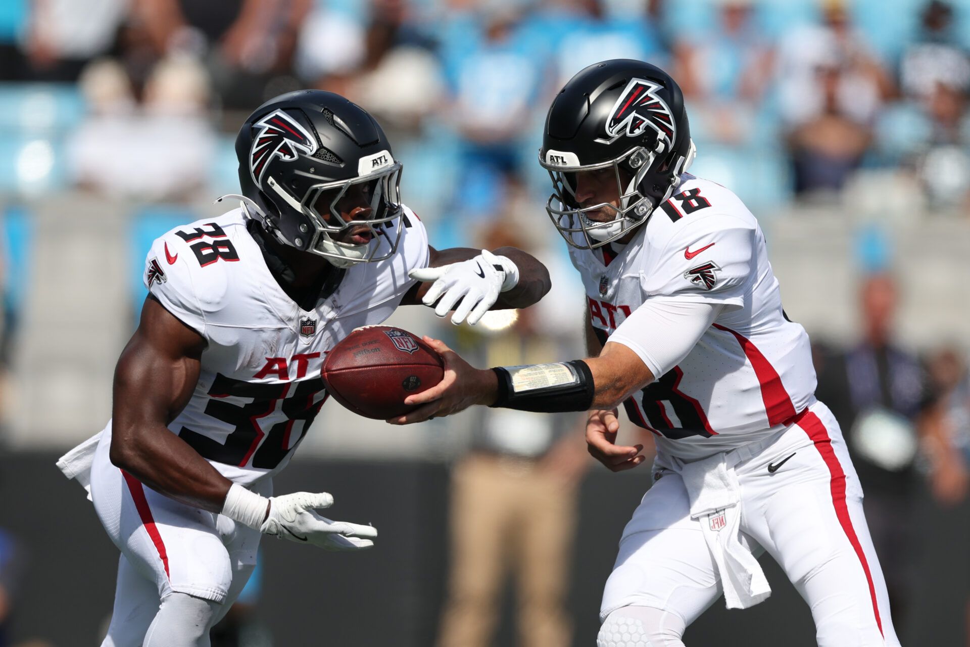 Atlanta Falcons quarterback Kirk Cousins (18) hands off the ball to running back Nate Carter (38) during the second half of a game against the Carolina Panthers at Bank of America Stadium.