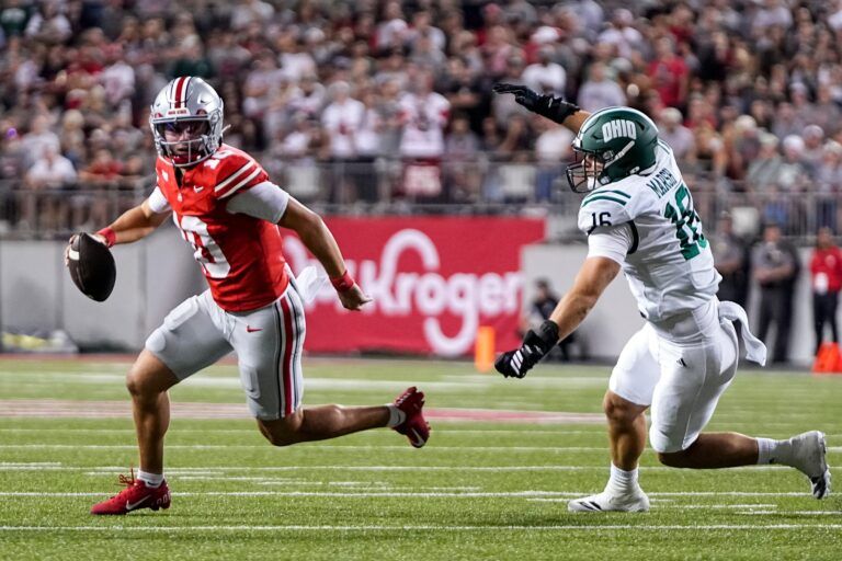 Ohio State Buckeyes quarterback Julian Sayin (10) runs away from Ohio Bobcats defensive end Joseph Marsh (16) during the NCAA football game at Ohio Stadium on Sept. 13, 2025. Ohio State won 37-9.