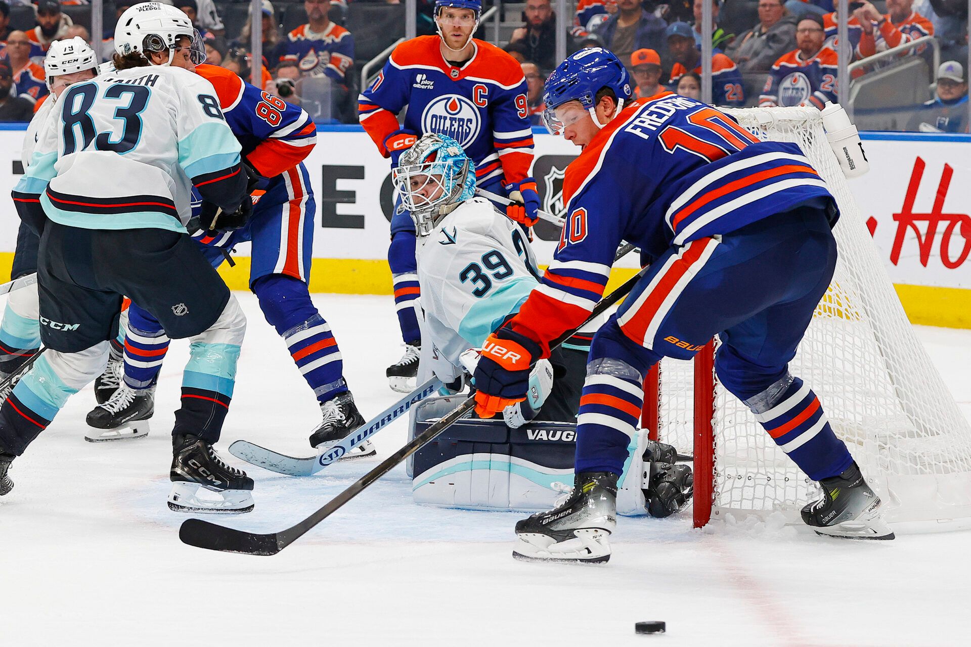 Edmonton Oilers forward Trent Frederic (10) can’t find a loose puck beside Seattle Kraken goaltender Nikke Kakko (30) during the third period at Rogers Place.