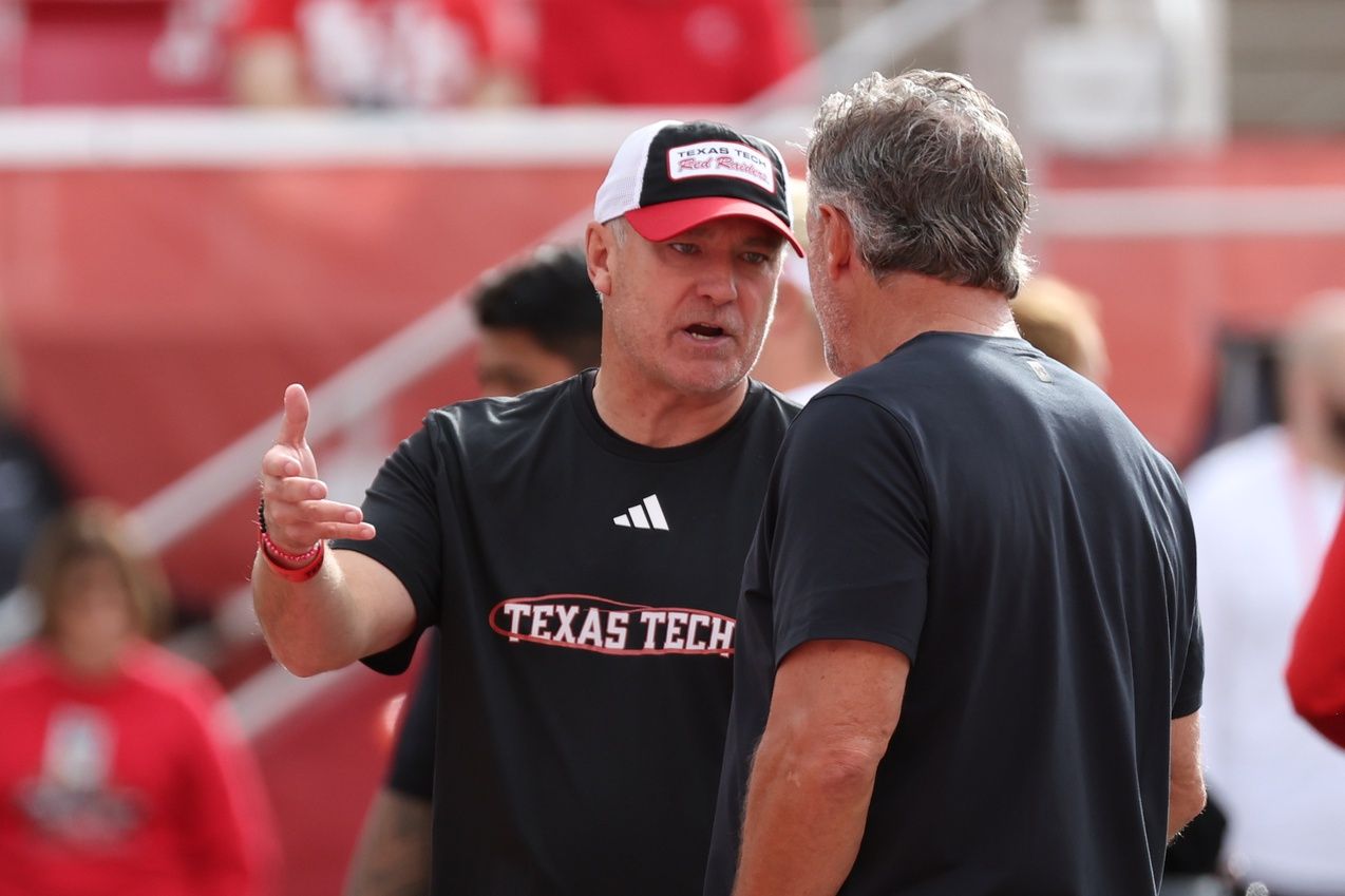 Texas Tech Red Raiders head coach Joey McGuire speaks with Utah Utes head coach Kyle Whittingham before the game at Rice-Eccles Stadium.