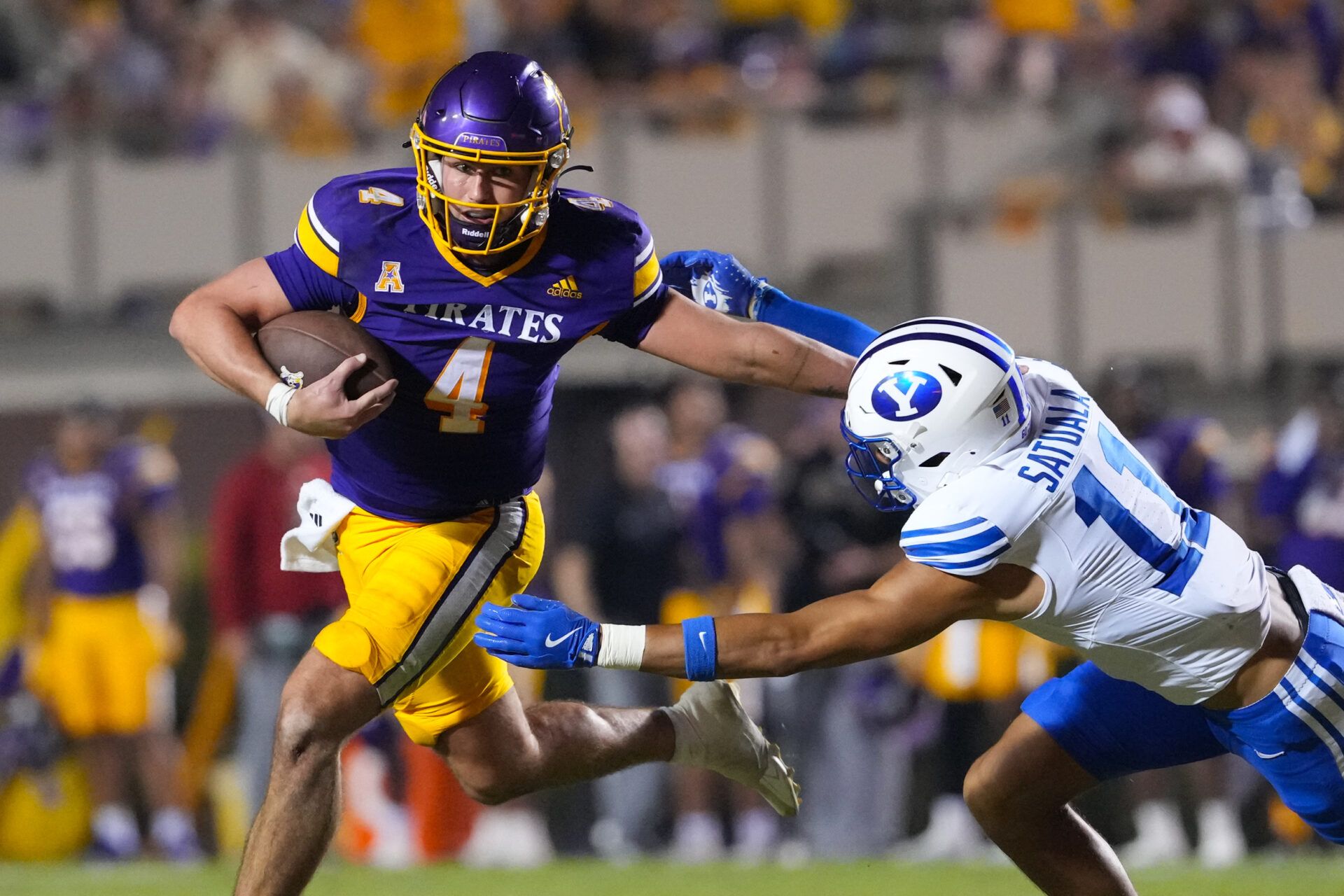 East Carolina Pirates quarterback Katin Houser (4) runs with the ball past Brigham Young Cougars safety Faletau Satuala (11) during the second half at Dowdy-Ficklen Stadium.