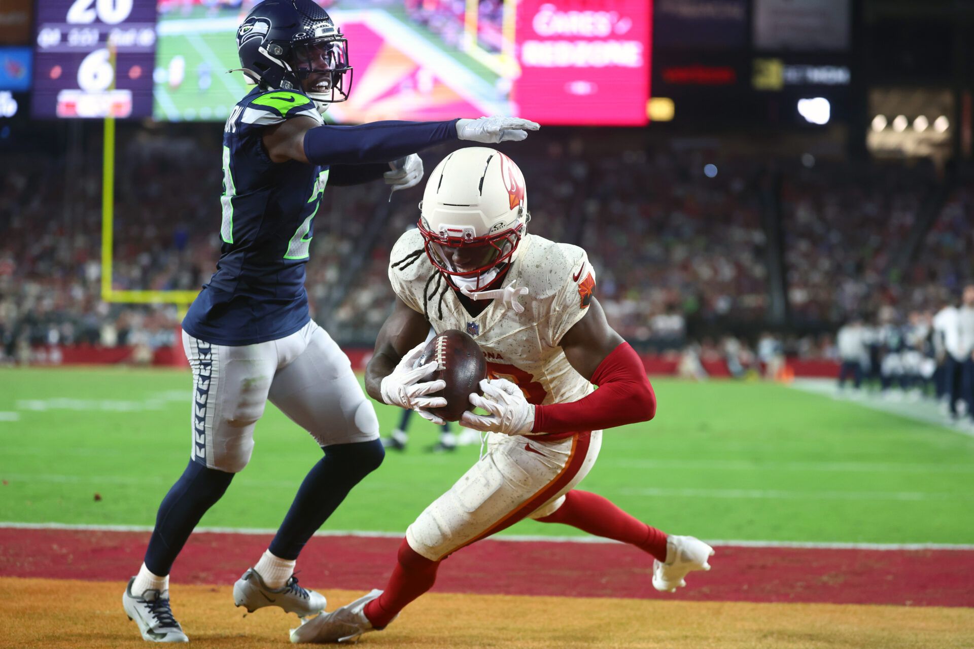 Arizona Cardinals wide receiver Marvin Harrison Jr. (18) makes a catch for a touchdown against Seattle Seahawks cornerback Devon Witherspoon (21) in the fourth quarter at State Farm Stadium.