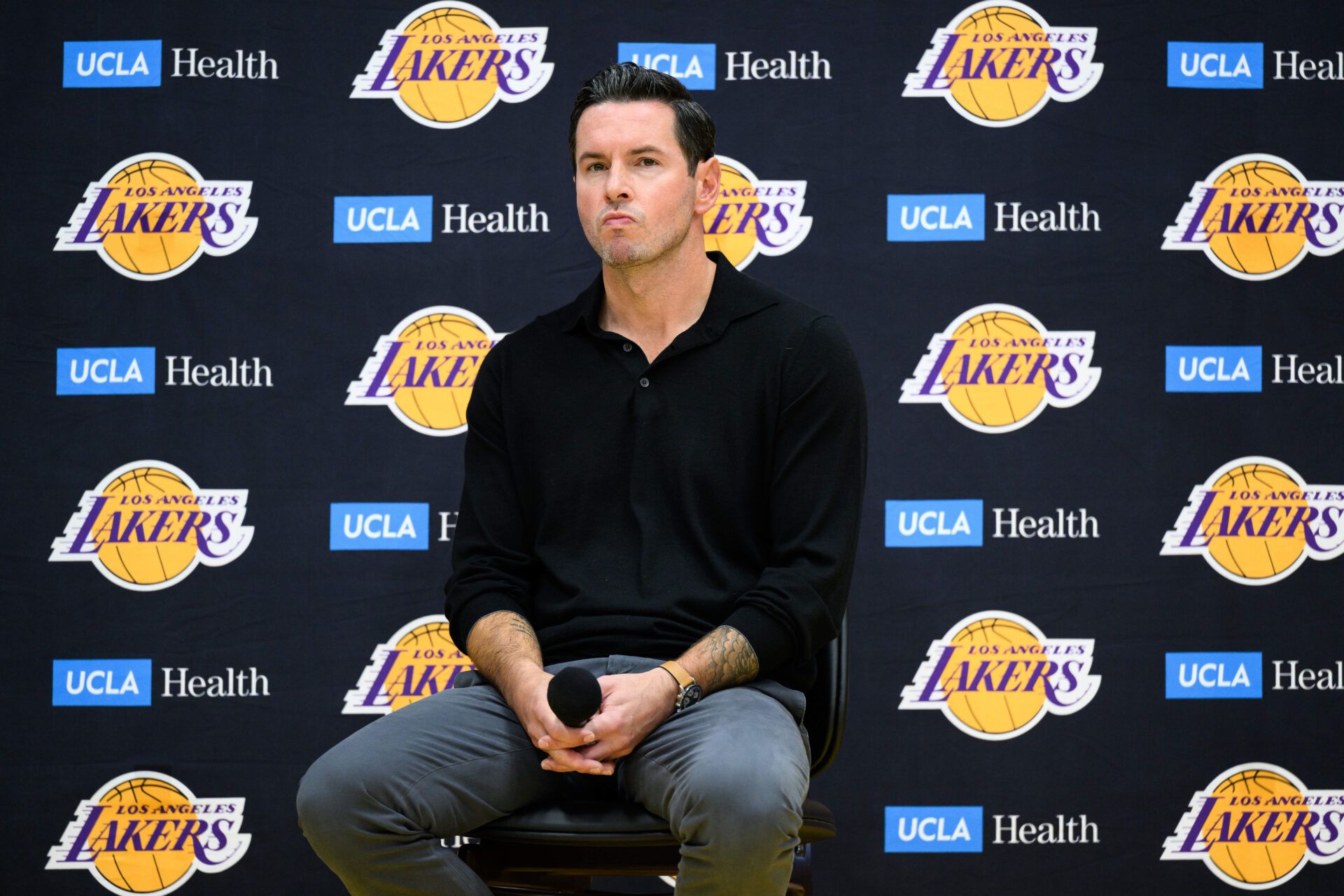 Los Angeles Lakers head coach JJ Redick, right, looks on during a press conference to preview the 2025-26 season at UCLA Health Training Center.