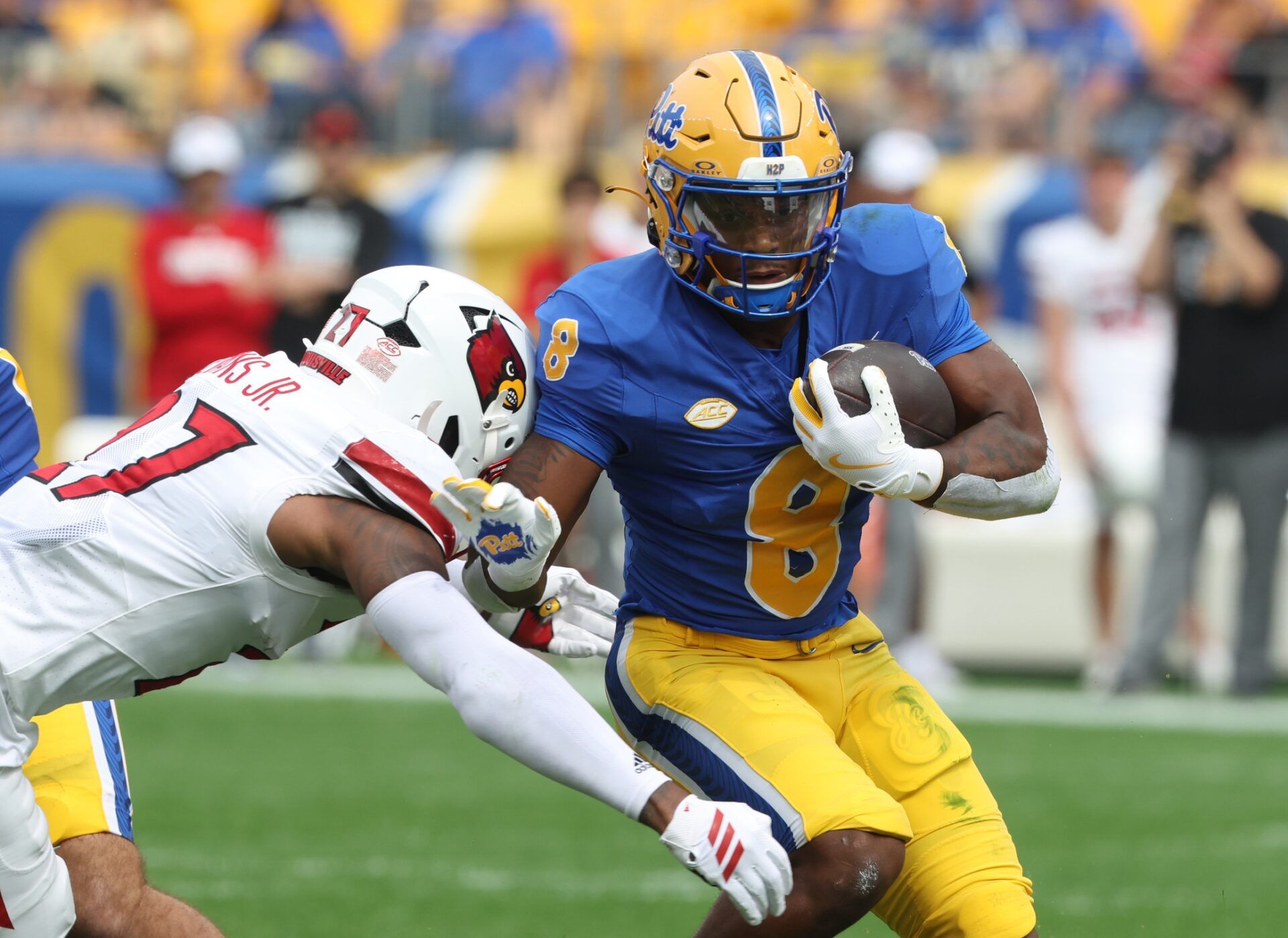 Pittsburgh Panthers running back Juelz Goff (8) runs the ball against Louisville Cardinals defensive back JoJo Evans Jr. (27) during the first quarter at Acrisure Stadium.