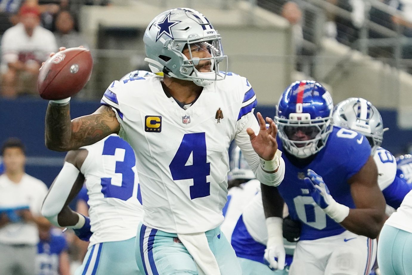 Dallas Cowboys quarterback Dak Prescott (4) looks to pass the ball against the New York Giants during the first quarter at AT&T Stadium.