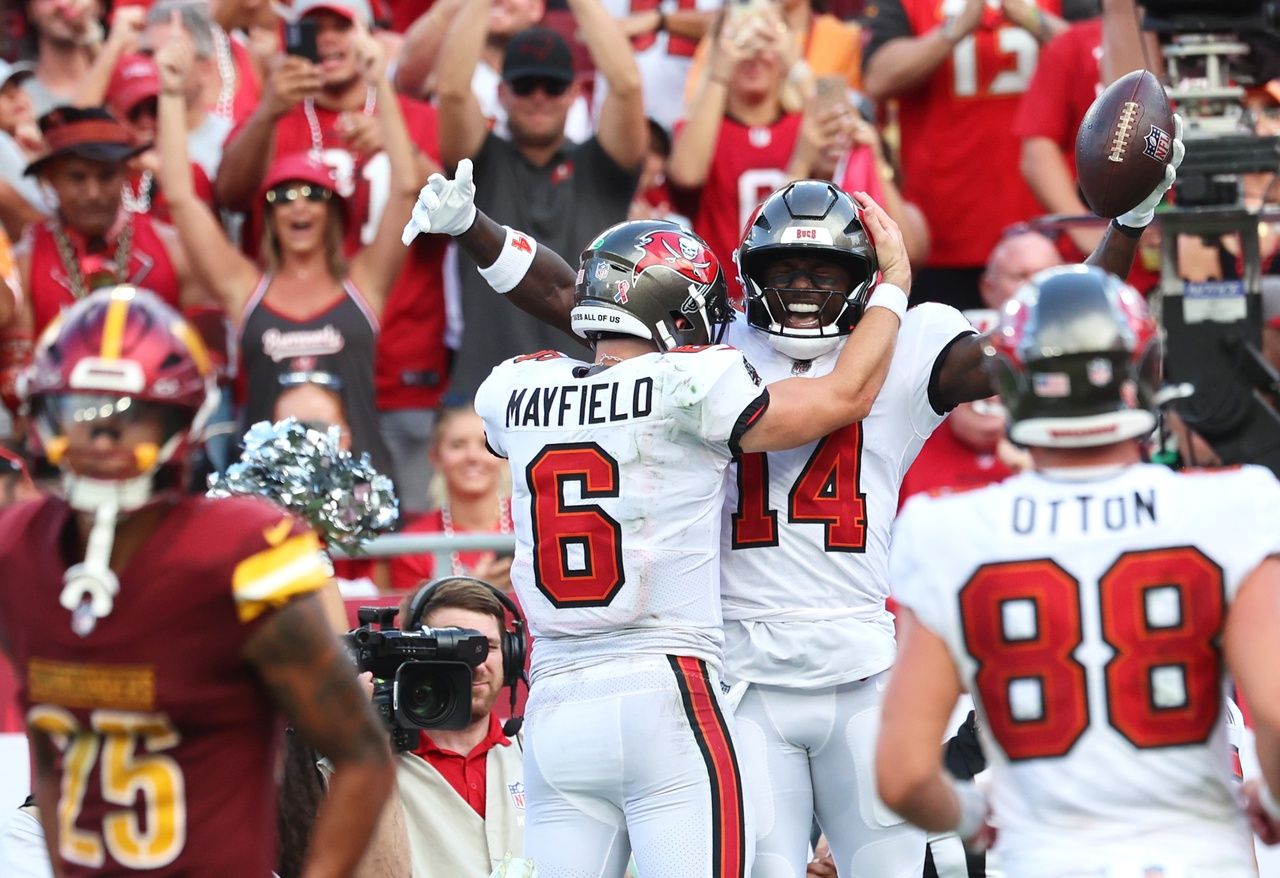 Tampa Bay Buccaneers wide receiver Chris Godwin (14) is congratulated by quarterback Baker Mayfield (6) after he scored a touchdown against the Washington Commanders during the second half at Raymond James Stadium.