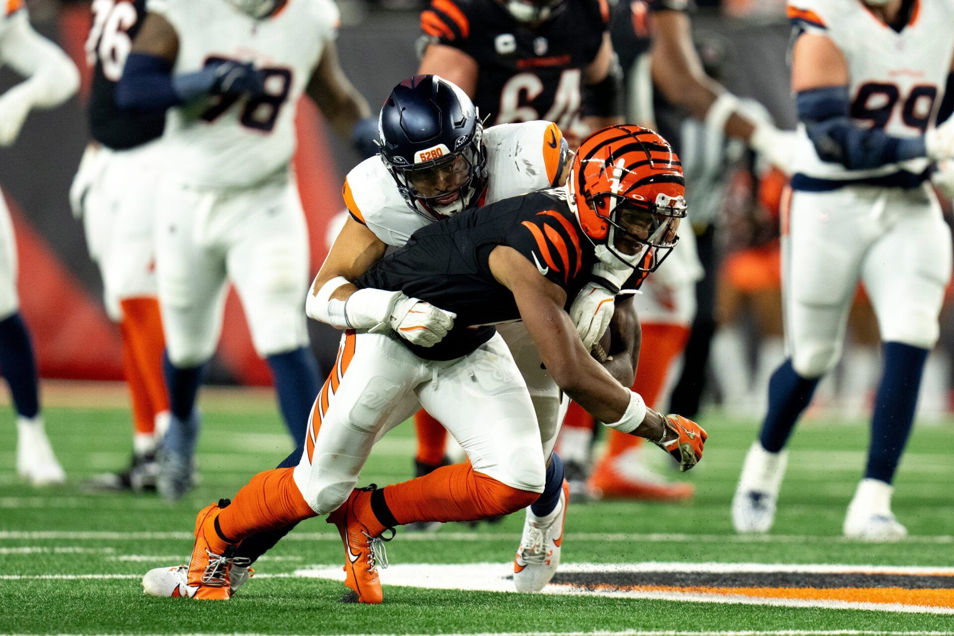 Denver Broncos inside linebacker Justin Strnad (40) tackles Cincinnati Bengals wide receiver Ja'Marr Chase (1) in the third quarter of the NFL game at Paycor Stadium in Cincinnati on Saturday, Dec. 28, 2024.