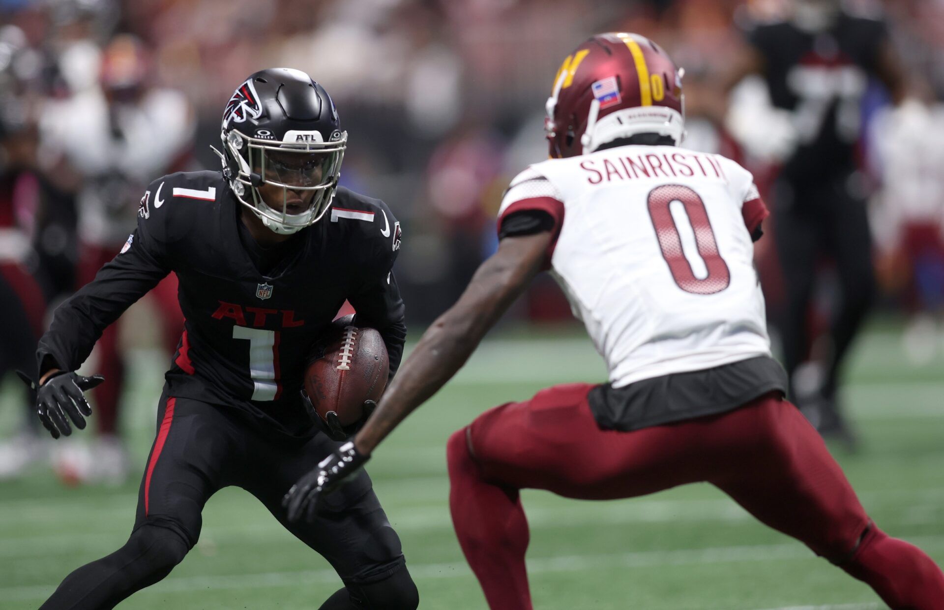 Atlanta Falcons wide receiver Darnell Mooney (1) runs against Washington Commanders cornerback Mike Sainristil (0) during the first half at Mercedes-Benz Stadium.