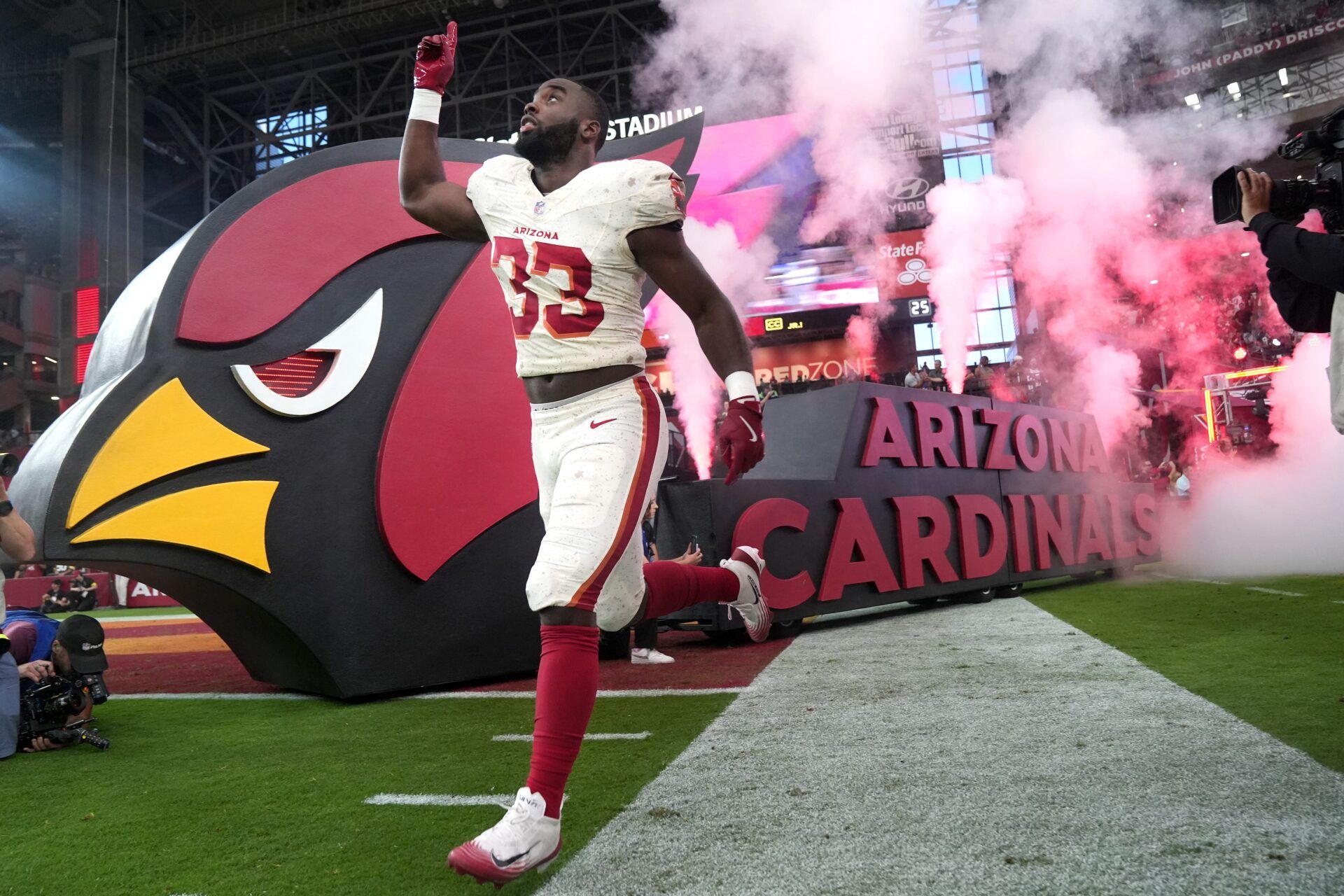 Arizona Cardinals running back Trey Benson (33) runs out on to the field before they play the Seattle Seahawks at State Farm Stadium in Glendale on Sept. 25, 2025.