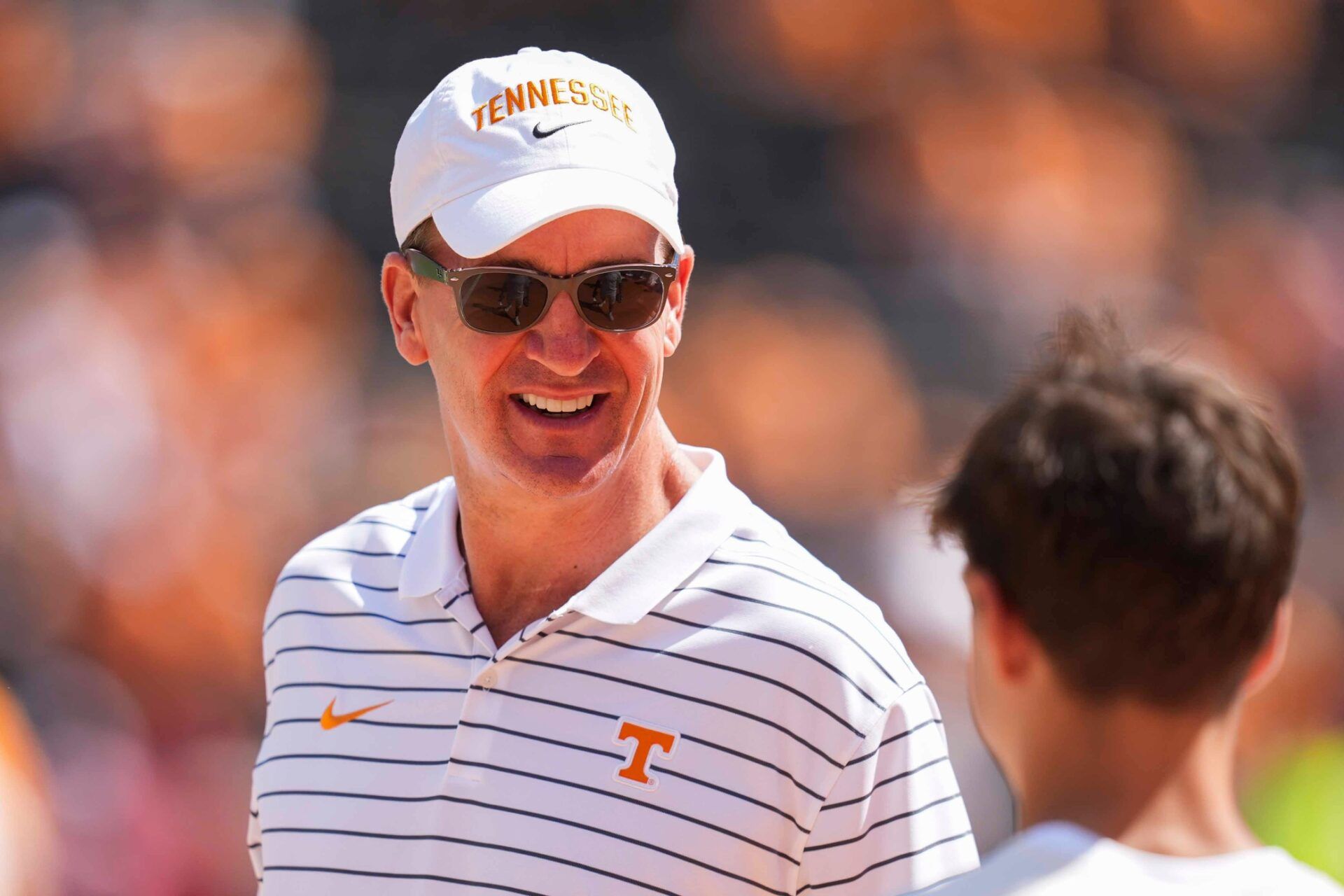 Peyton Manning smiles at a fan on the sidelines before a NCAA football game between Tennessee and Georgia at Neyland Stadium in Knoxville, Tennessee, on September 13, 2025.