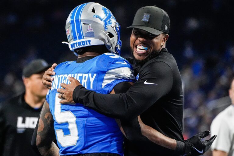 Detroit Lions running backs coach Tashard Rice hugs running back David Montgomery (5) during warm up ahead of the Cleveland Browns game at Ford Field in Detroit on Sunday, Sept. 28, 2025.