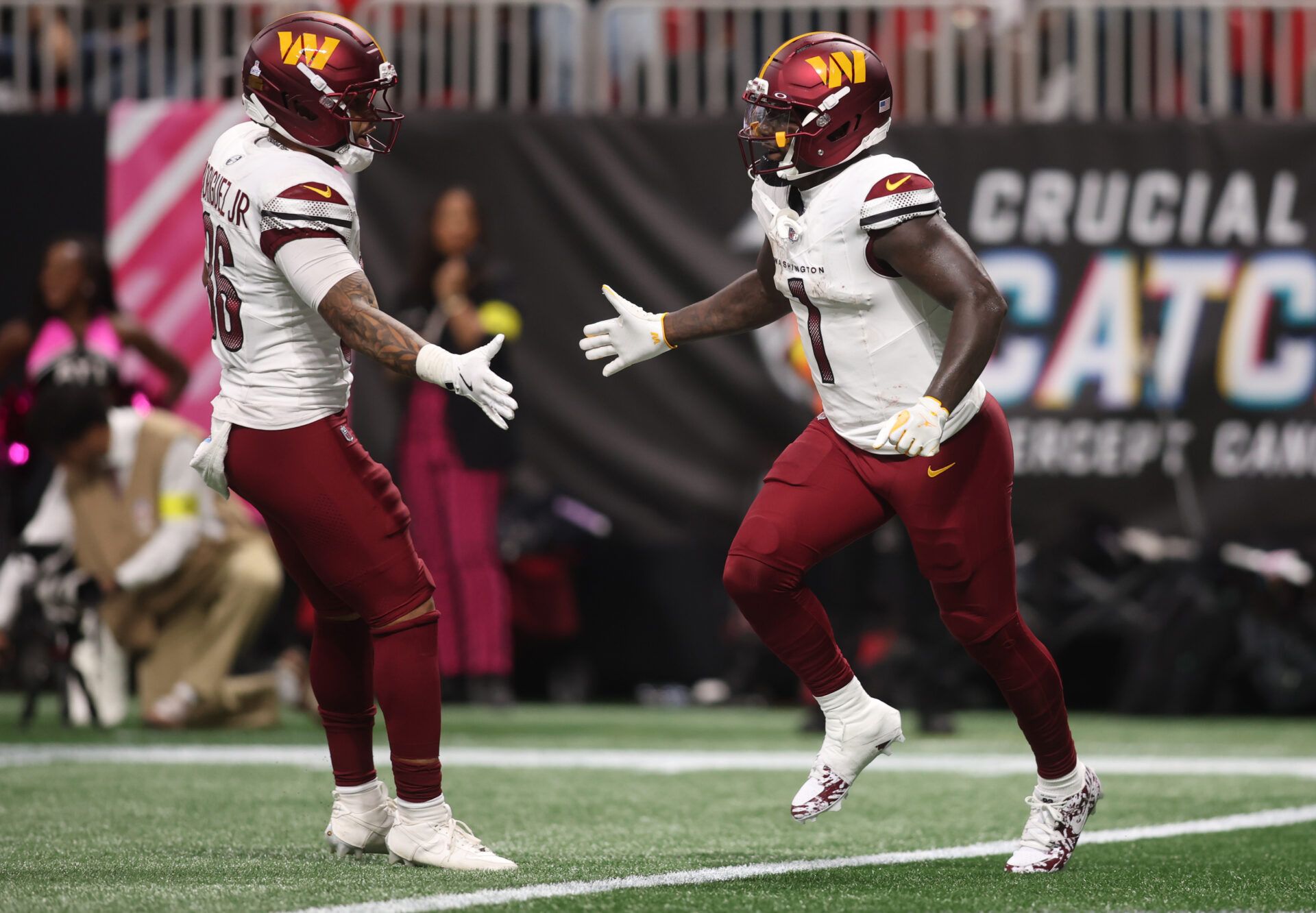 Washington Commanders wide receiver Deebo Samuel Sr. (1) celebrates with running back Chris Rodriguez Jr. (36) after scoring a touchdown during the second half against the Atlanta Falcons at Mercedes-Benz Stadium.