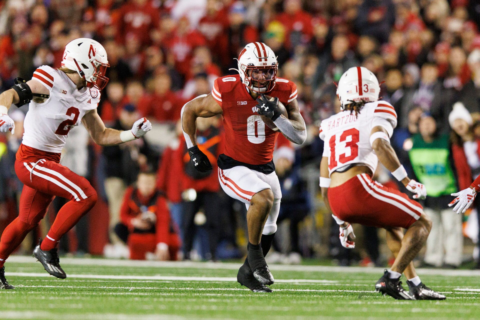 Wisconsin Badgers running back Braelon Allen (0) rushes with the football between Nebraska Cornhuskers defensive backs Isaac Gifford (2) and Malcolm Hartzog (13) during the fourth quarter against = at Camp Randall Stadium.