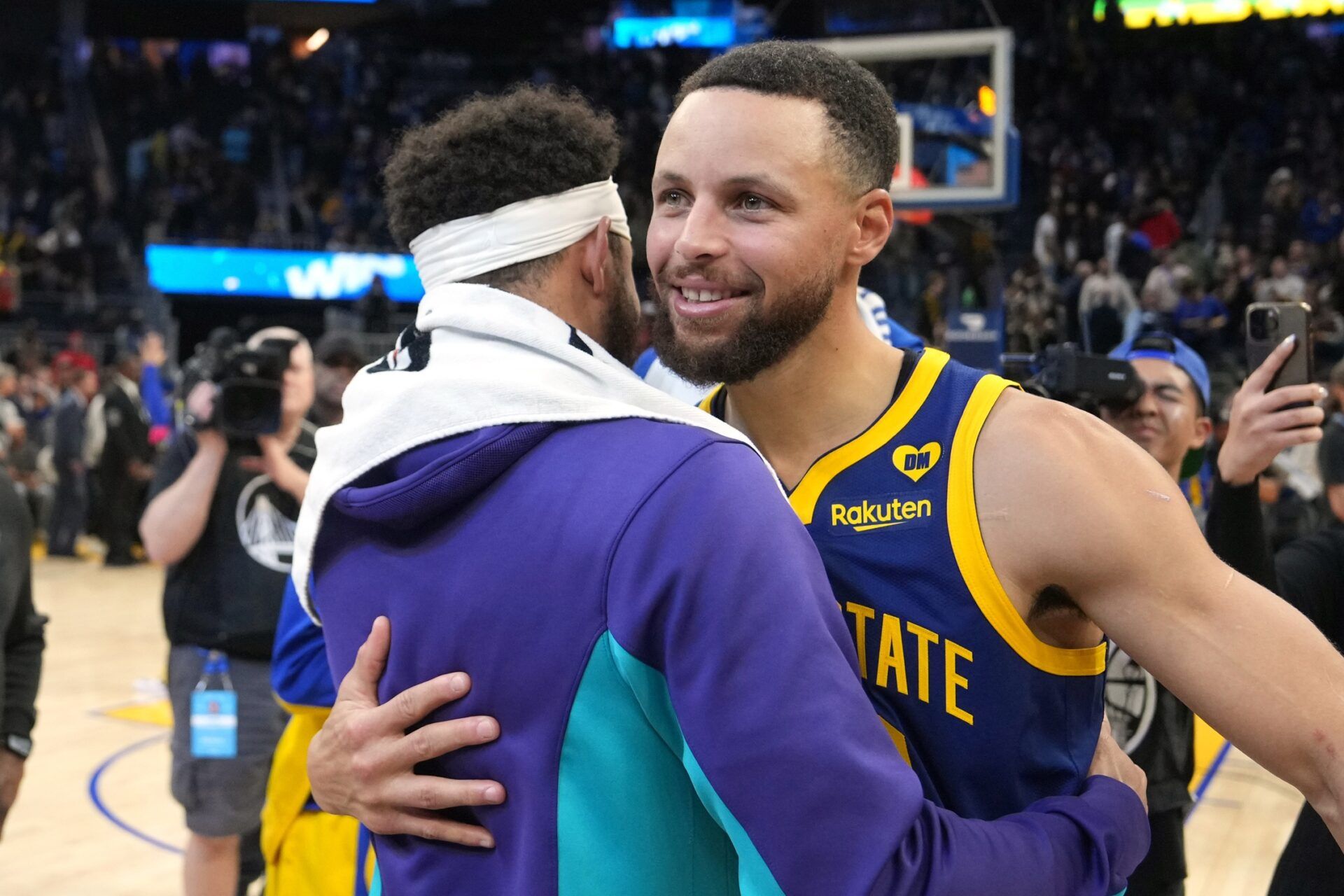 Golden State Warriors guard Stephen Curry (right) hugs Charlotte Hornets guard Seth Curry (left) after the game at Chase Center.