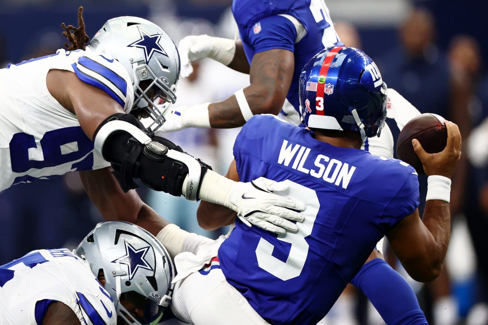 Dallas Cowboys defensive tackle Osa Odighizuwa (97) dives for New York Giants quarterback Russell Wilson (3) during the second quarter at AT&T Stadium.
