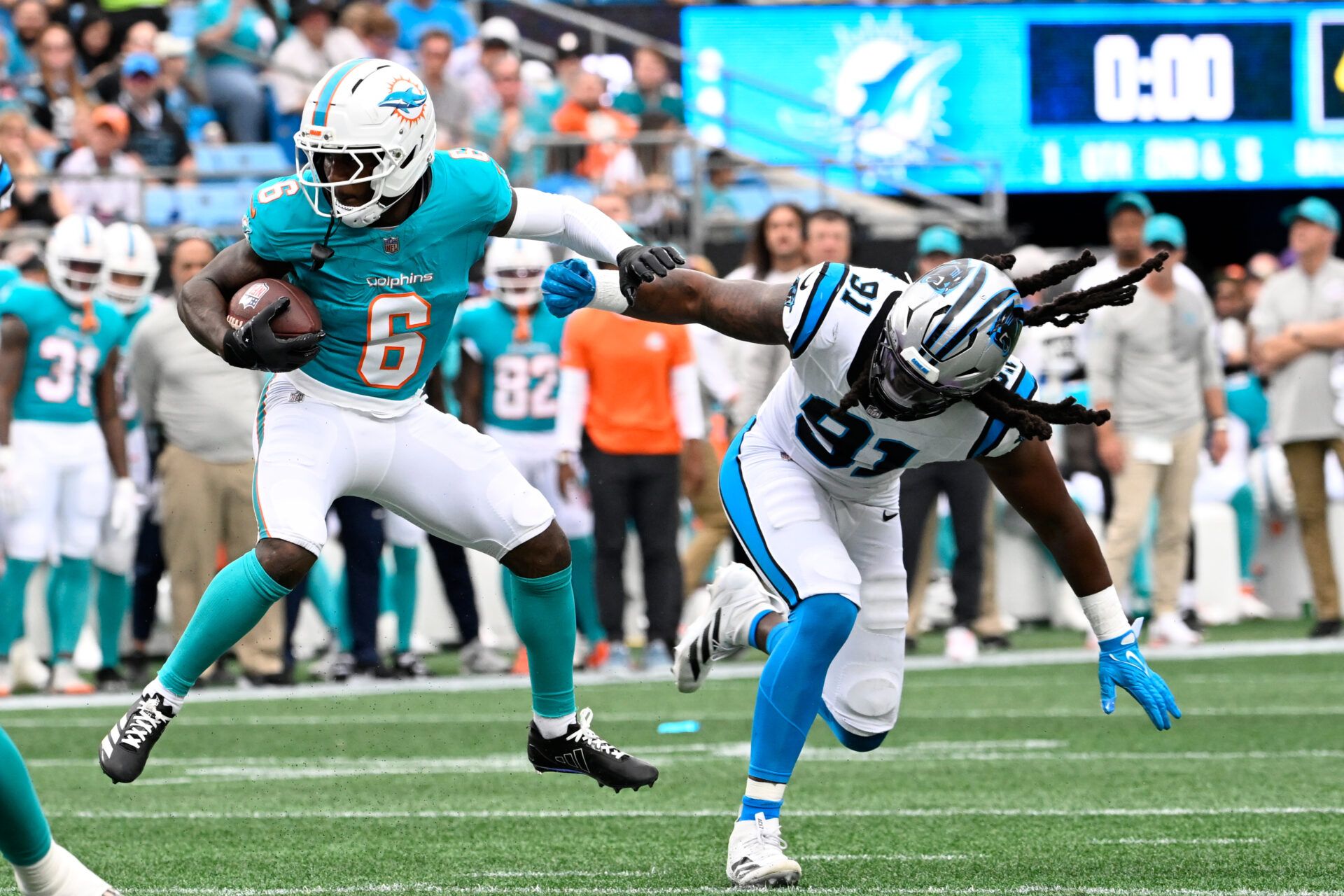 Miami Dolphins wide receiver Malik Washington (6) with the ball as Carolina Panthers linebacker Patrick Jones II (91) defends in the first quarter at Bank of America Stadium.