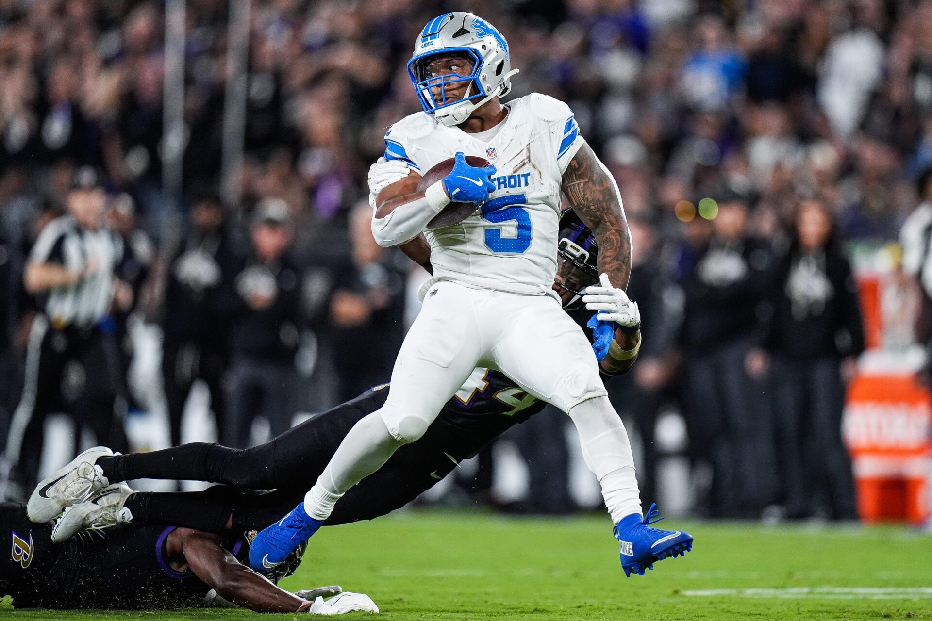 Detroit Lions running back David Montgomery (5) runs against Baltimore Ravens cornerback Marlon Humphrey (44) and defensive tackle Broderick Washington (96) during the second half at M&T Bank Stadium in Baltimore, Md. on Monday, Sept. 22, 2025.