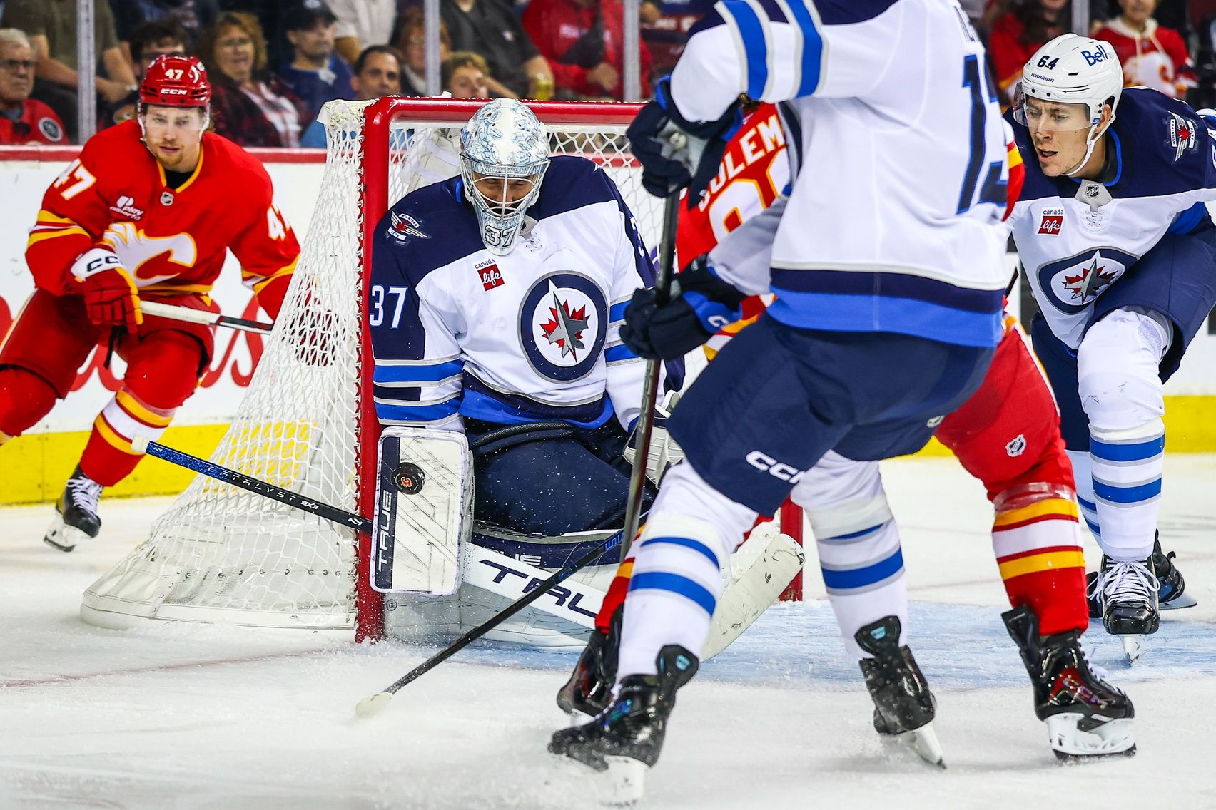 Winnipeg Jets goaltender Connor Hellebuyck (37) makes a save against the Calgary Flames during the second period at Scotiabank Saddledome.