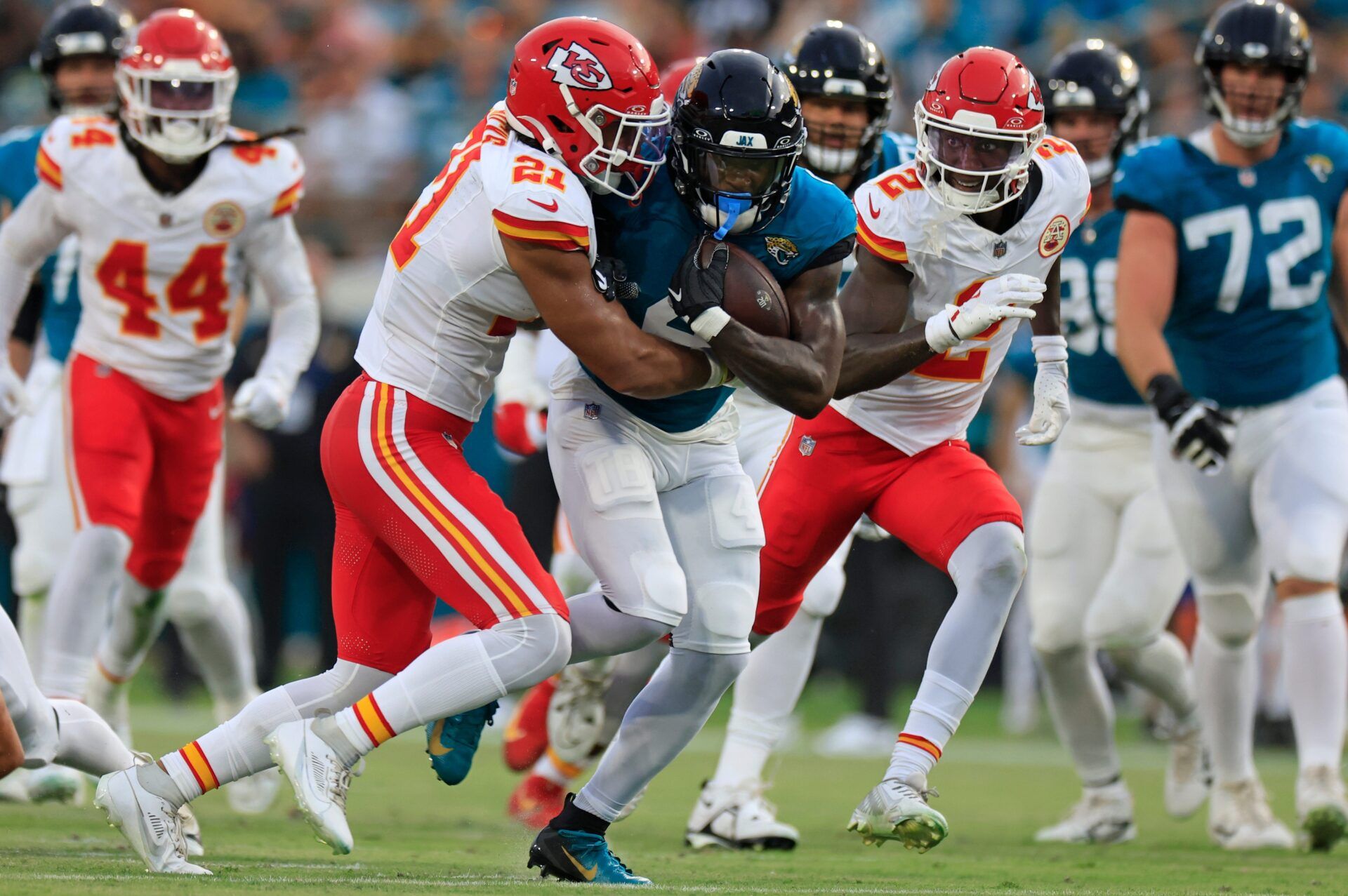 Jacksonville Jaguars running back Tank Bigsby (4) is tackled by Kansas City Chiefs safety Jaden Hicks (21) as cornerback Joshua Williams (2) looks on during the first quarter of a preseason NFL football game Saturday, Aug. 10, 2024 at EverBank Stadium in Jacksonville, Fla. [Corey Perrine/Florida Times-Union]