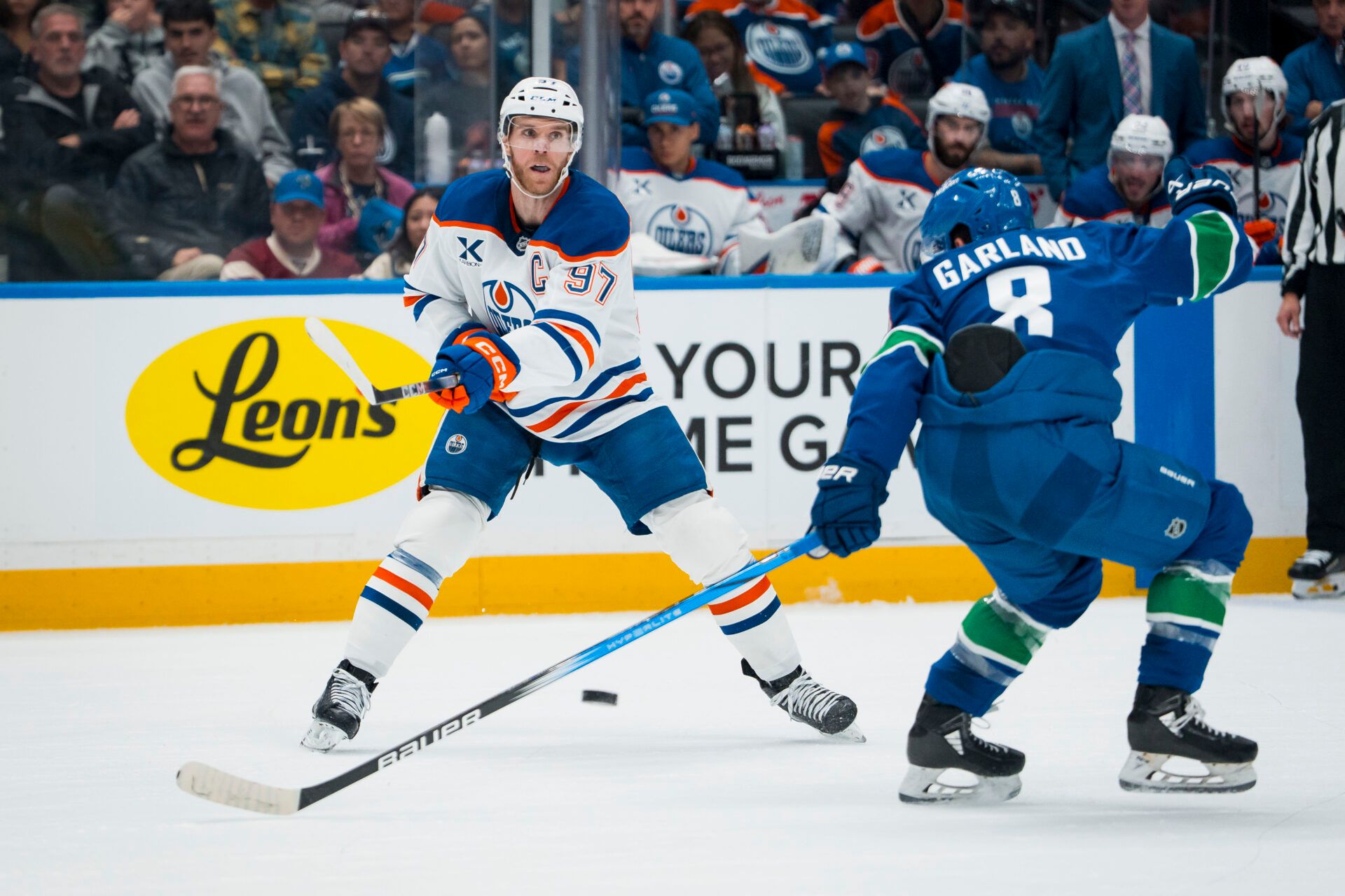 Edmonton Oilers forward Connor McDavid (97) passes around Vancouver Canucks forward Conor Garland (8) in the second period at Rogers Arena.