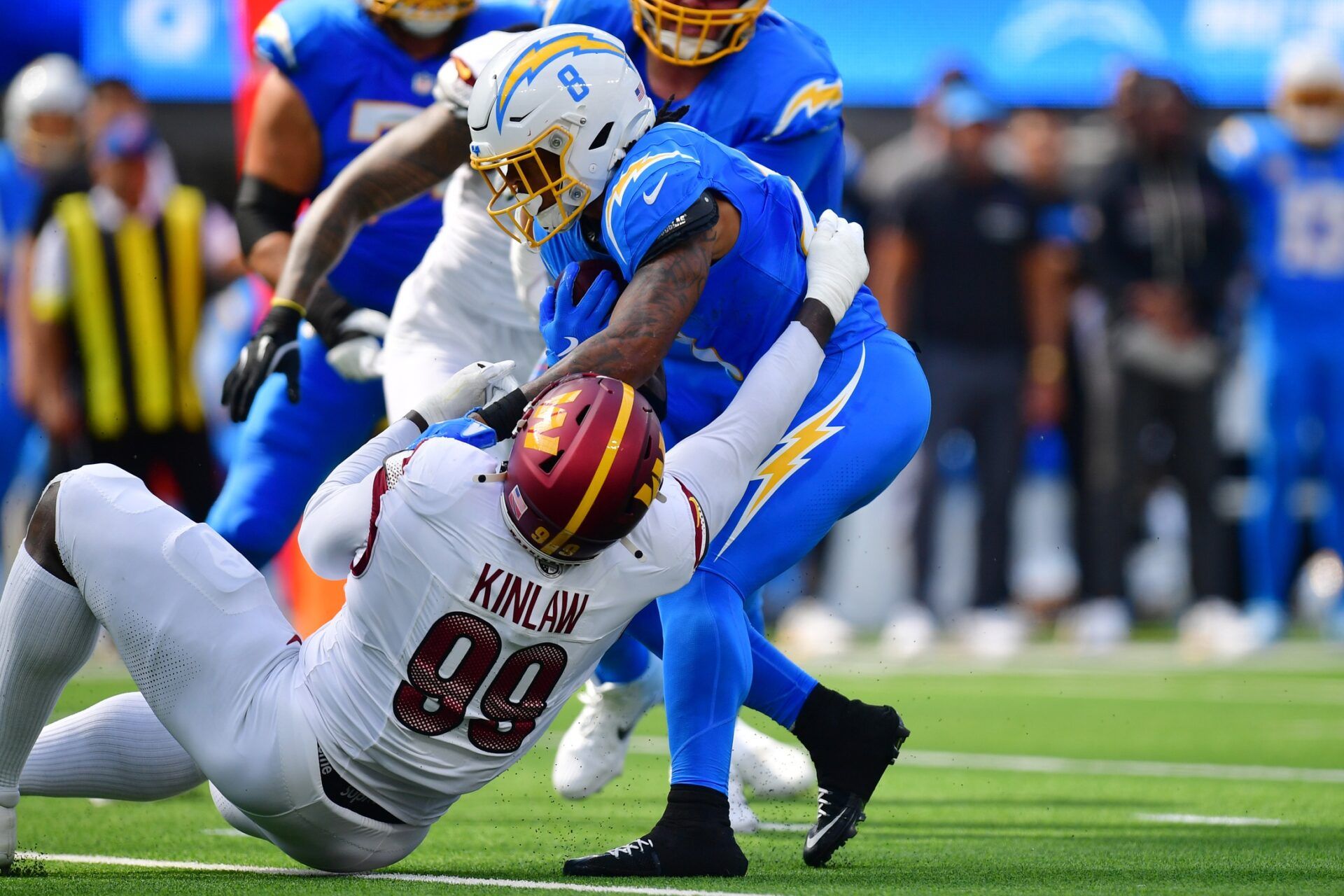 Los Angeles Chargers running back Omarion Hampton (8) runs against Washington Commanders defensive tackle Javon Kinlaw (99) in the first half at SoFi Stadium.