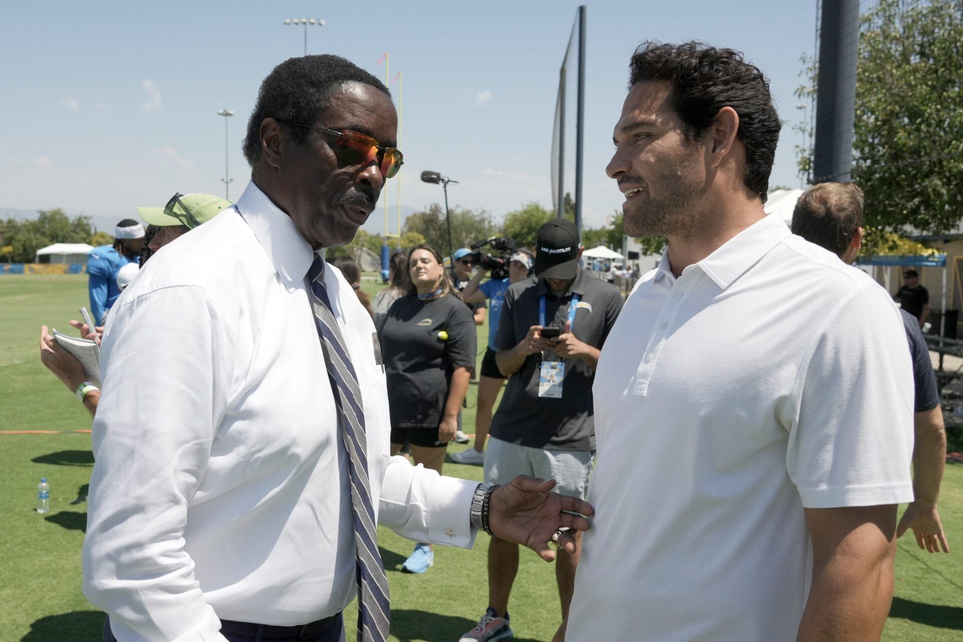 CAL/CBS sports director Jim Hill (left) talks with Mark Sanchez during joint practice between the Los Angeles Chargers and the Dallas Cowboys at Jack Hammett Sports Complex.