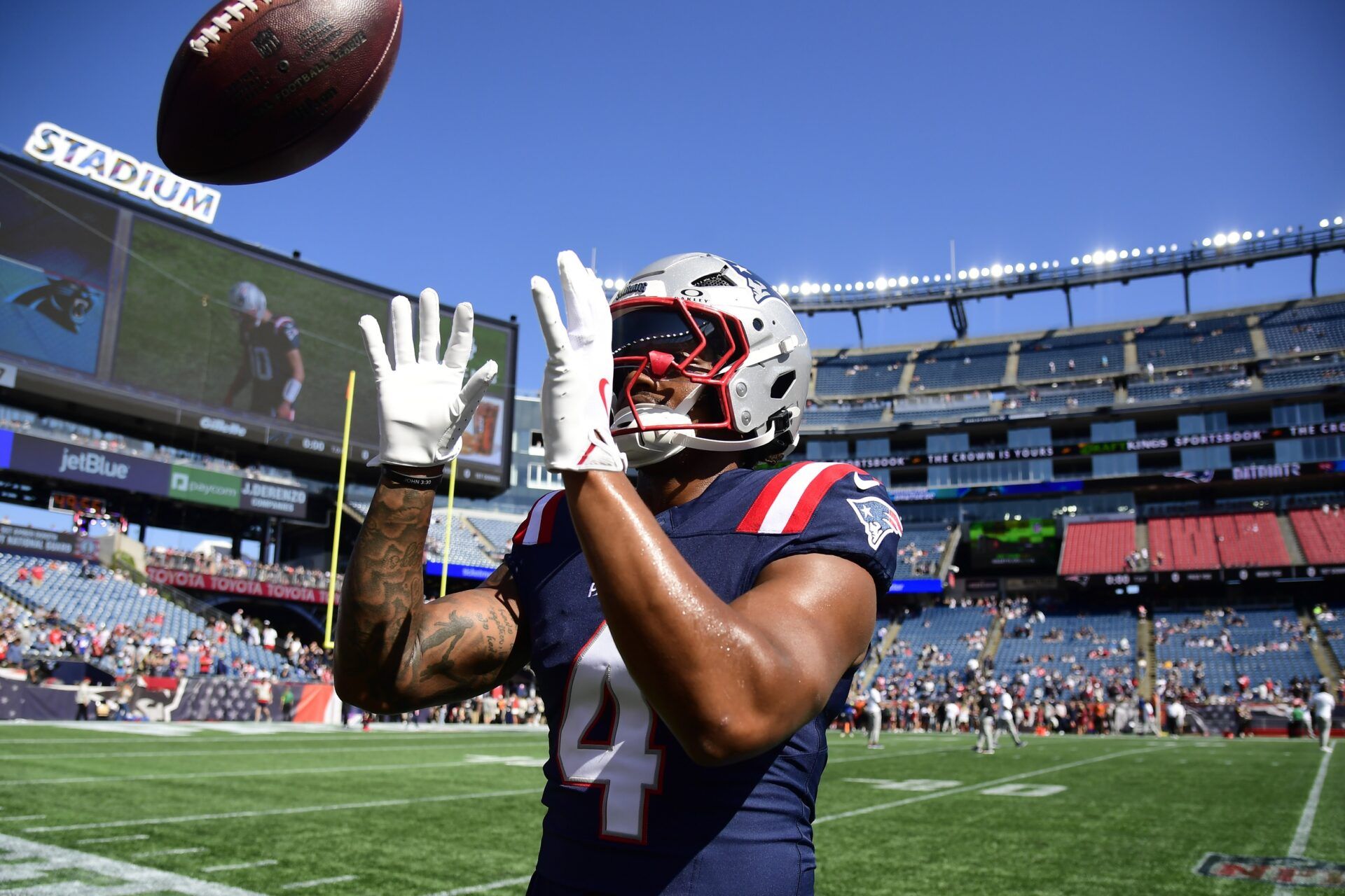 New England Patriots running back Antonio Gibson (4) plays catch with fans prior to a game against the Carolina Panthers at Gillette Stadium.