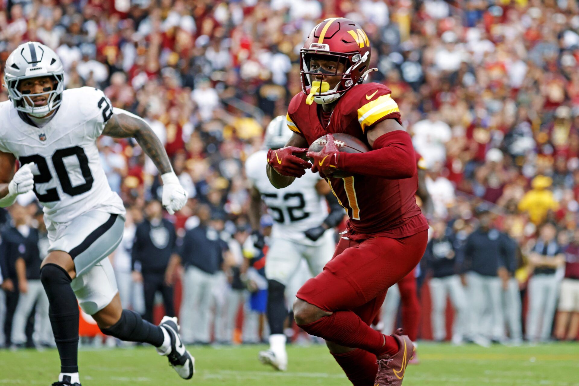 Washington Commanders wide receiver Terry McLaurin (17) runs the ball during the second half as Las Vegas Raiders safety Isaiah Pola-Mao (20) defends at Northwest Stadium.