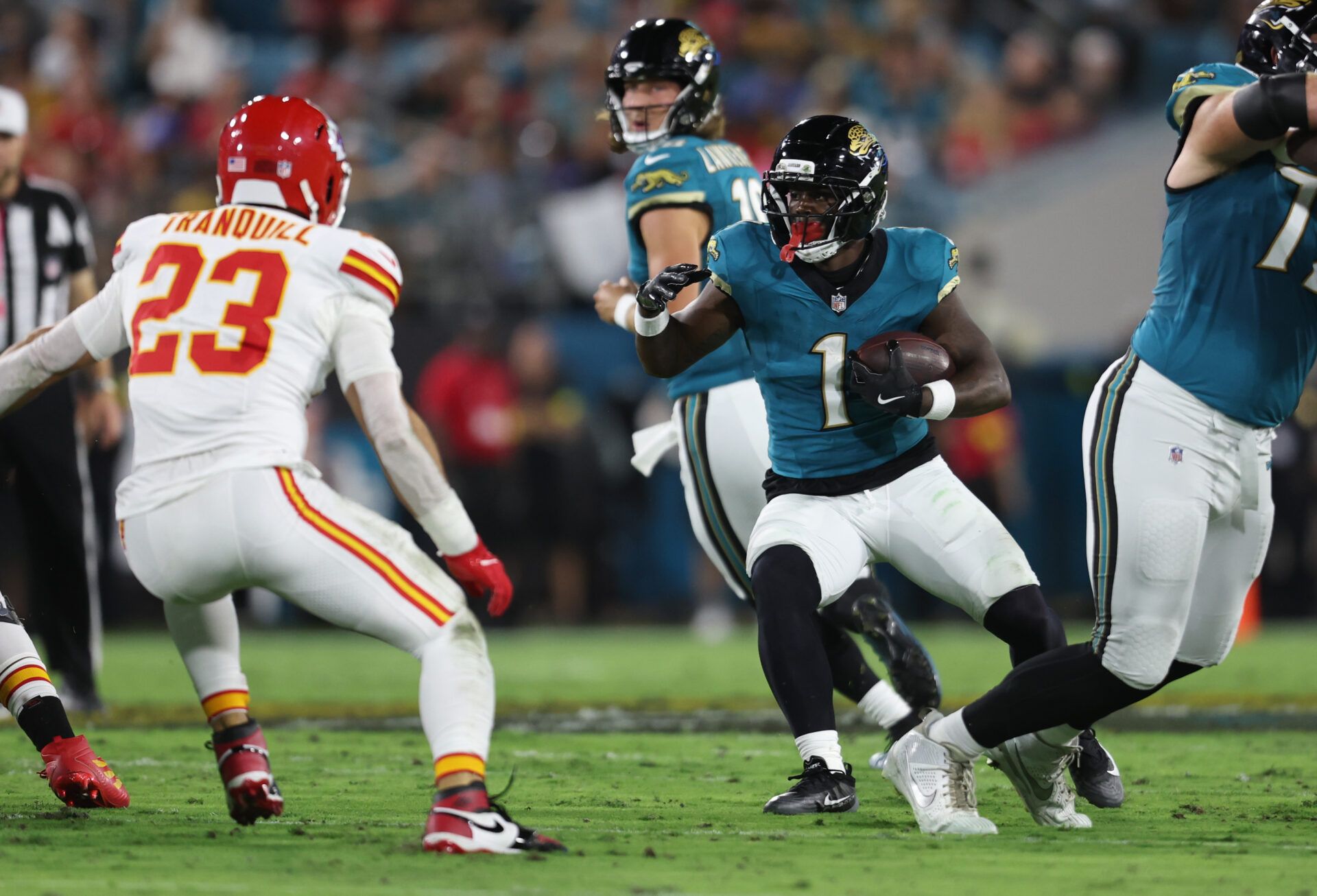 Jacksonville Jaguars running back Travis Etienne (1) runs against Kansas City Chiefs linebacker Drue Tranquill (23) during the first quarter at EverBank Stadium.