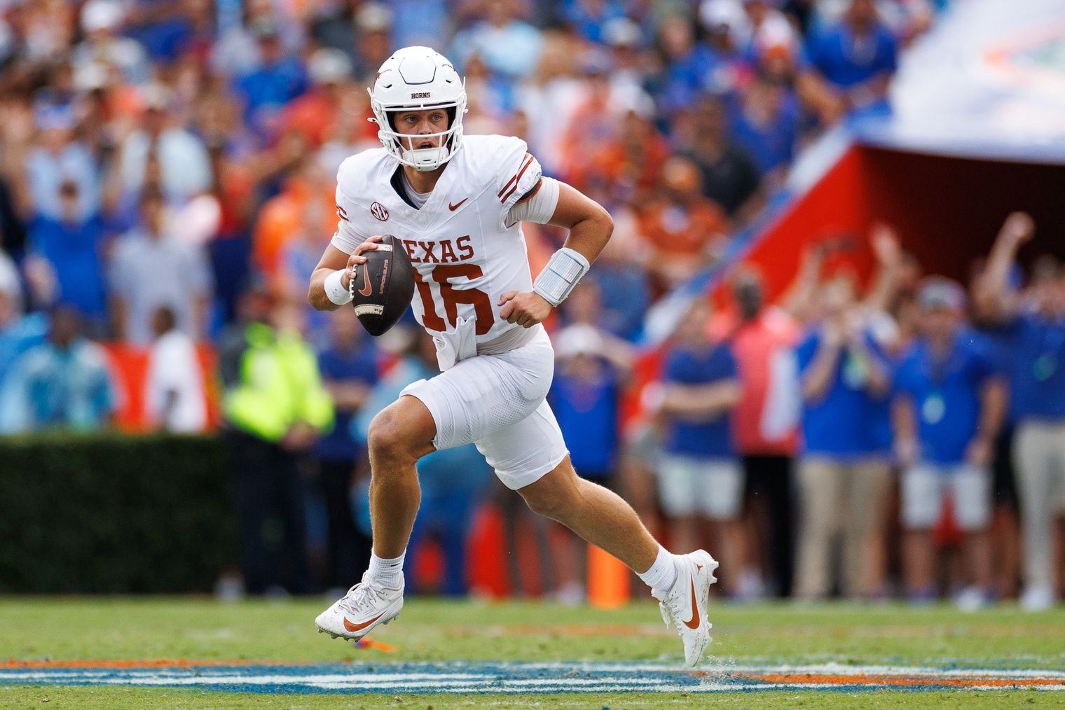 Texas Longhorns quarterback Arch Manning (16) scrambles with the ball against the Florida Gators during the first half at Ben Hill Griffin Stadium.