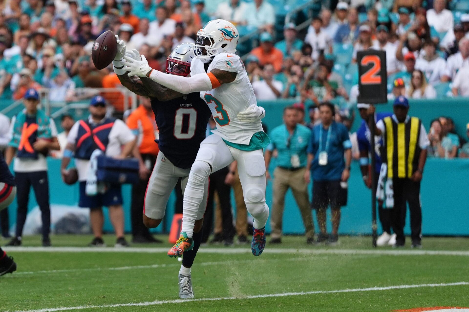 New England Patriots cornerback Christian Gonzalez (0) breaks up a pass to Miami Dolphins wide receiver Odell Beckham Jr. (3) during the first half at Hard Rock Stadium.