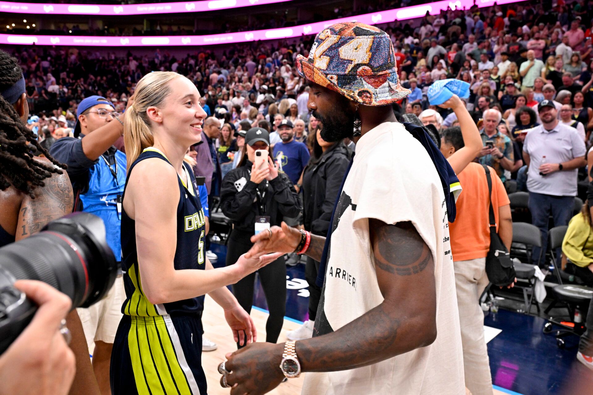Dallas Mavericks point guard Kyrie Irving talks with Dallas Wings guard Paige Bueckers (5) after the game against the Indiana Fever at the American Airlines Center.