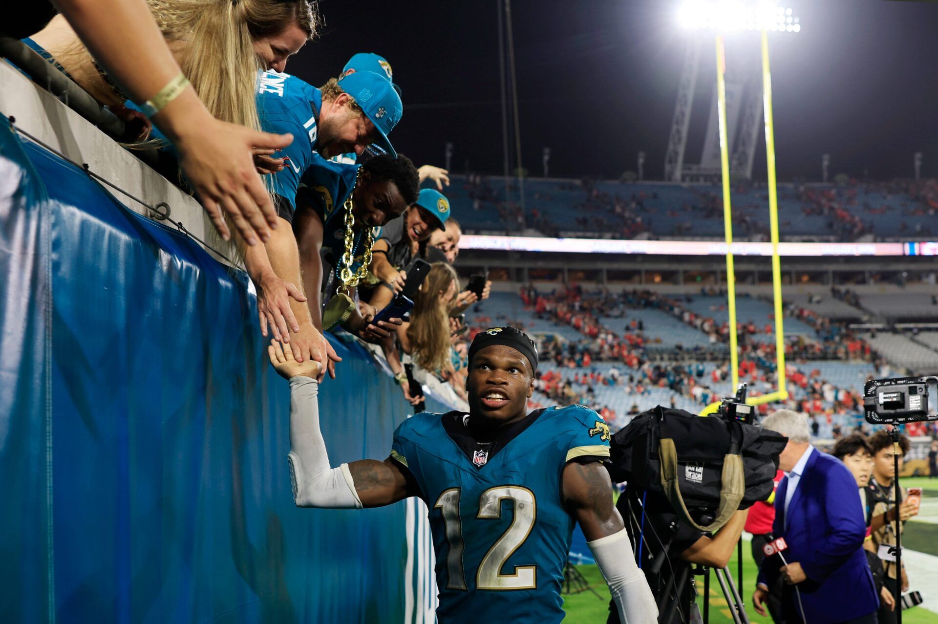 Jacksonville Jaguars wide receiver Travis Hunter (12) high-fives fans after the game of an NFL football matchup at EverBank Stadium, Monday, Oct. 6, 2025, in Jacksonville, Fla. The Jacksonville Jaguars edged the Kansas City Chiefs 31-28. [Corey Perrine/Florida Times-Union]