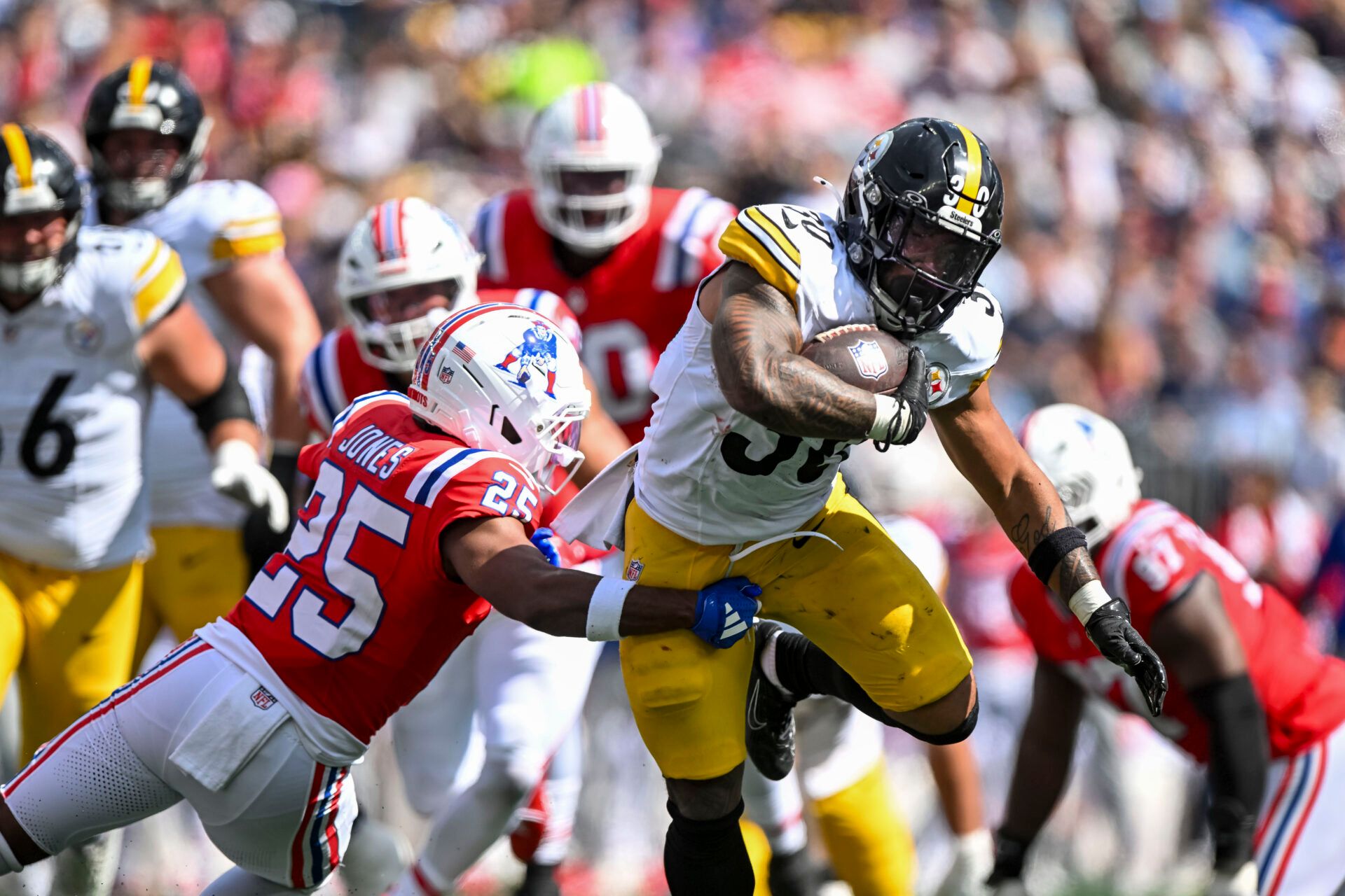 New England Patriots cornerback Marcus Jones (25) tackles Pittsburgh Steelers running back Jaylen Warren (30) during the second quarter at Gillette Stadium.