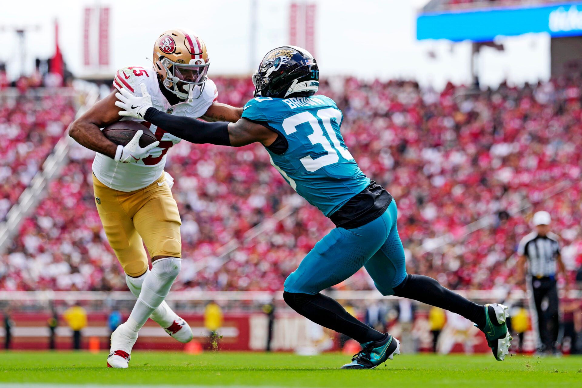 San Francisco 49ers wide receiver Jauan Jennings (15) runs the ball as Jacksonville Jaguars cornerback Montaric Brown (30) defends during the second half at Levi's Stadium.