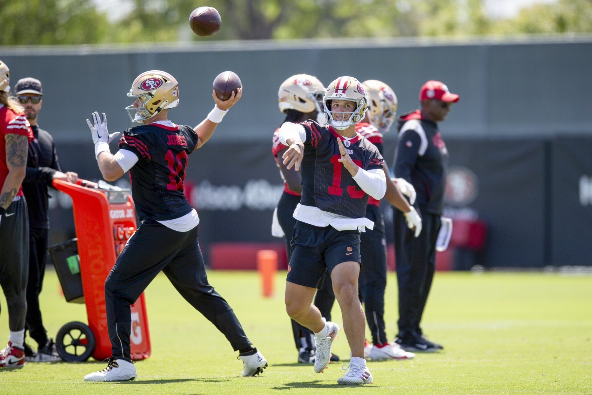 San Francisco 49ers quarterbacks Mac Jones (10) and Brock Purdy (13) work on passing drills during a team OTA at Levi's Stadium.
