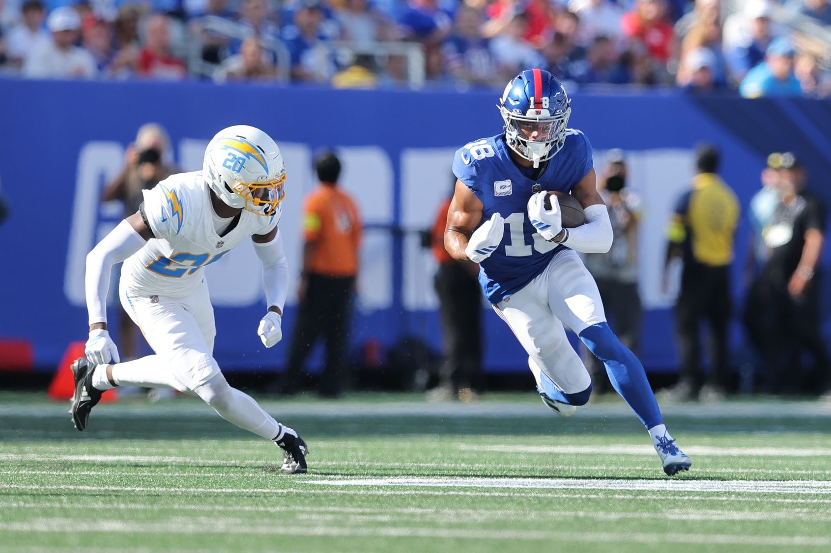 New York Giants wide receiver Darius Slayton (18) runs with the ball as Los Angeles Chargers cornerback Cam Hart (20) defends during the third quarter at MetLife Stadium.